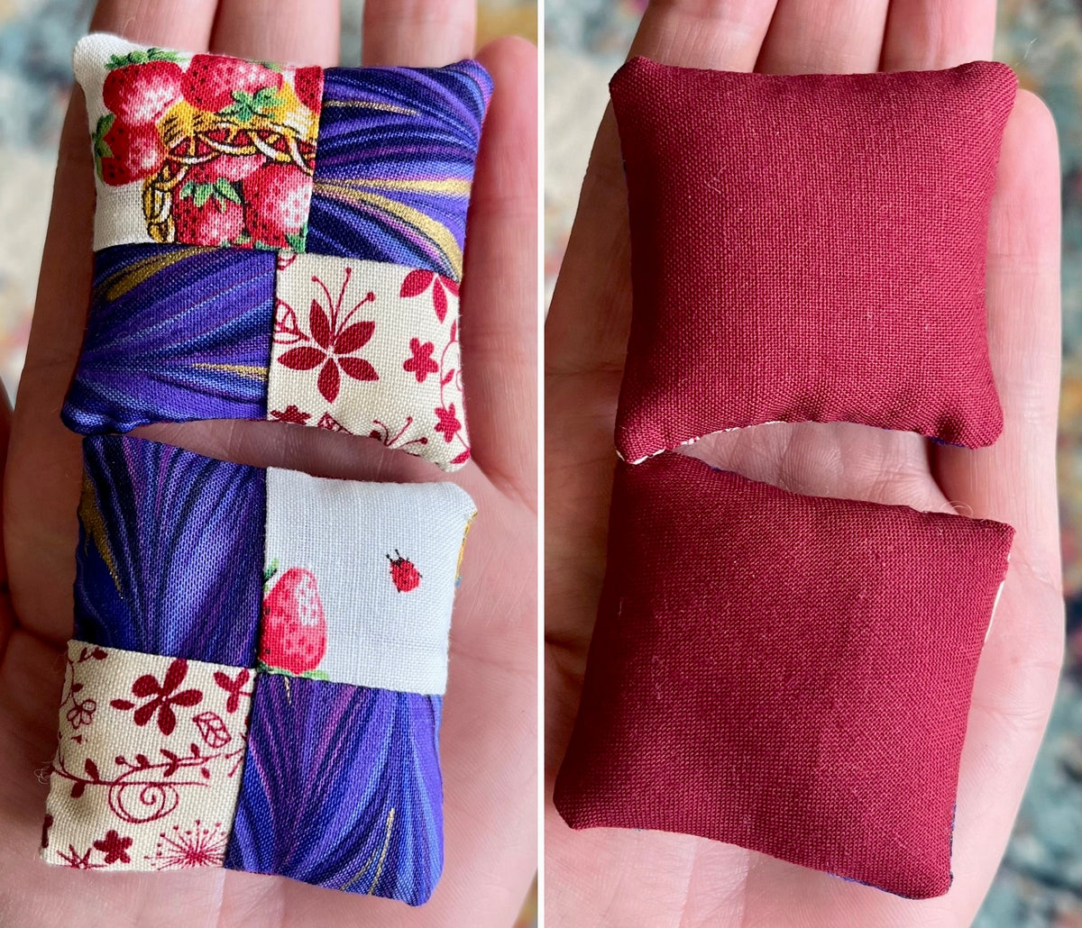 Two fabric pillows, front patchwork strawberries and purple, and back solid red, held in hands.