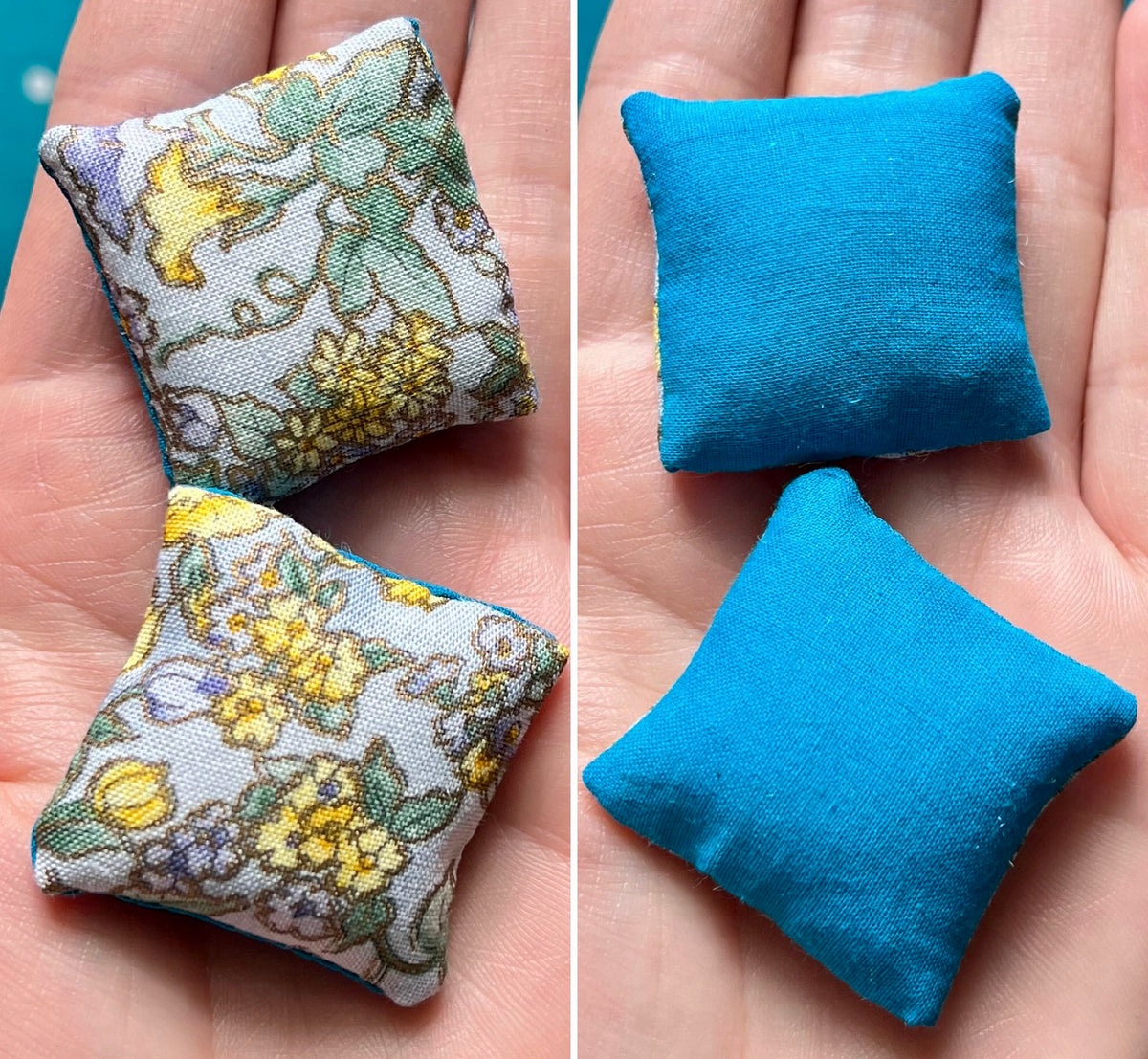 Two small fabric pillows, front floral and back solid blue, held in a hand.