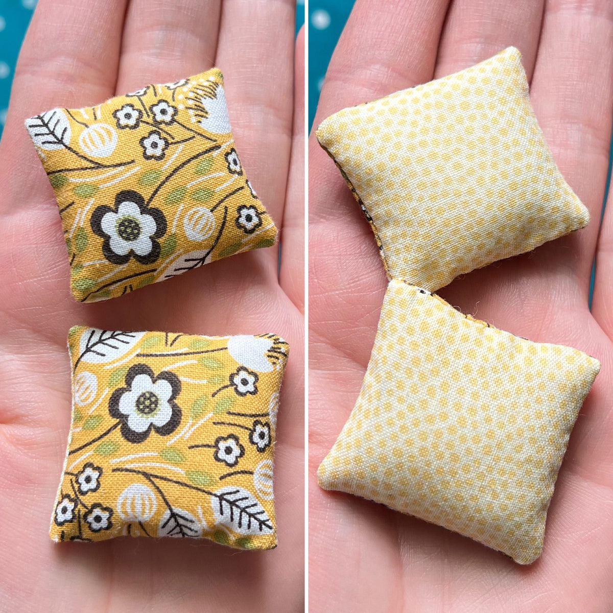 Two small fabric pillows with floral patterns held in a hand.