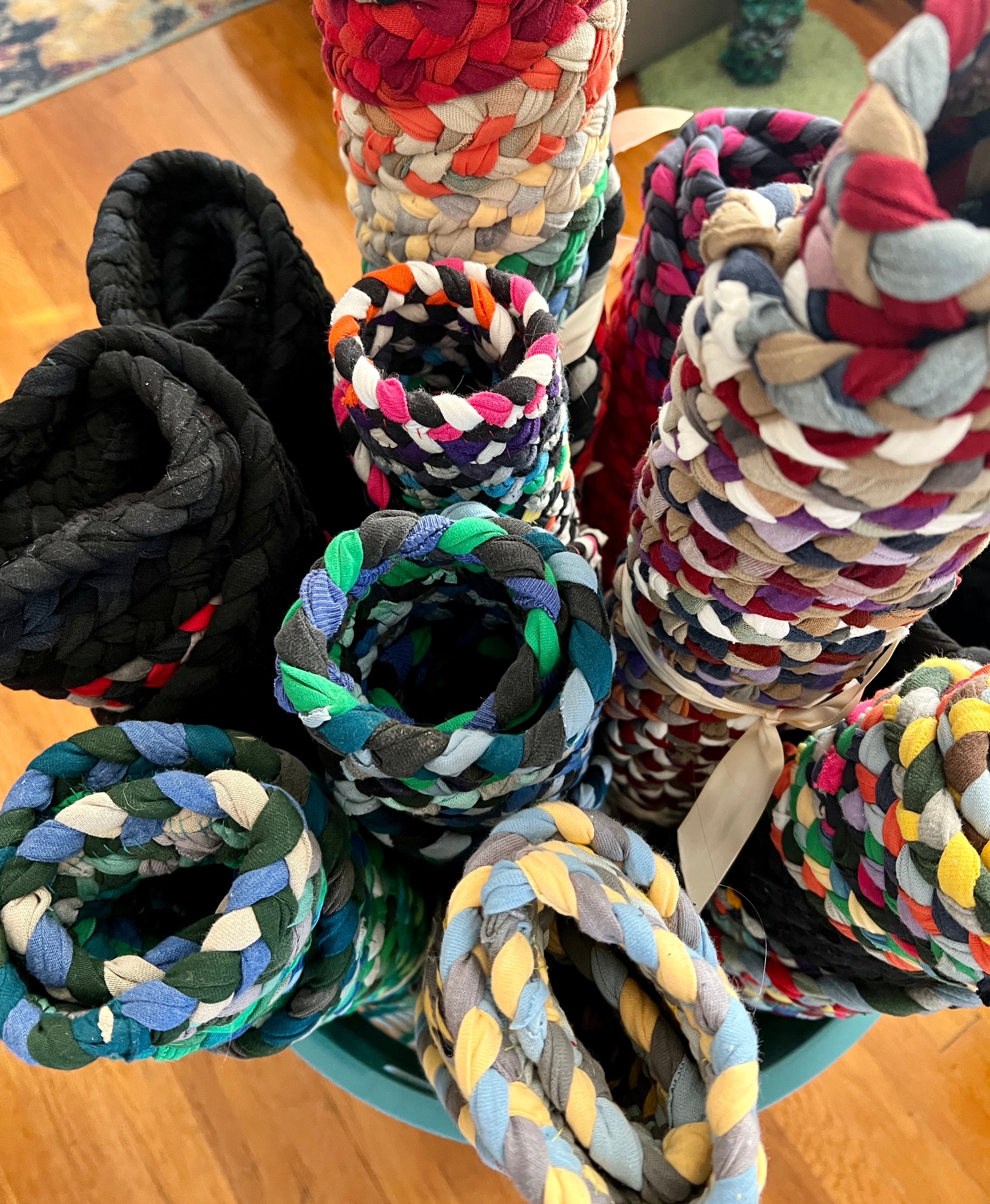 top view of a bunch of rolled up tshirt rugs, showing the ends and thickness of rugs