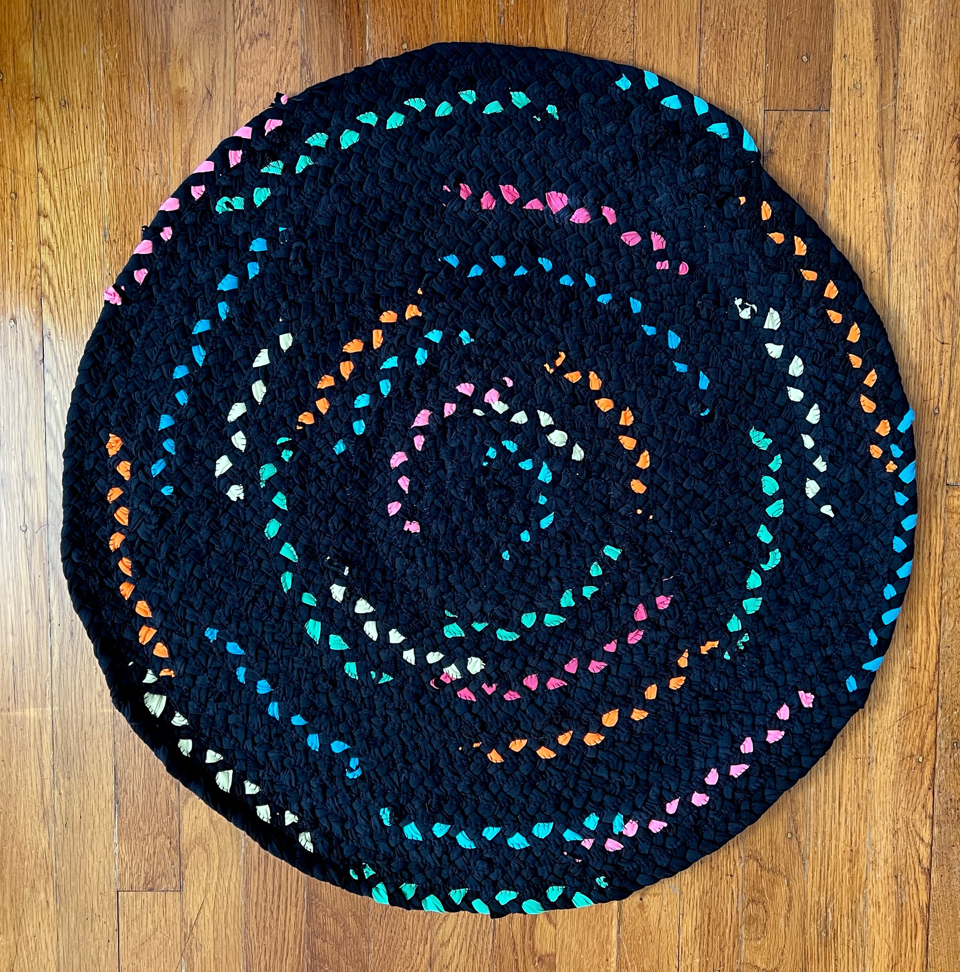 Neon colors run sporadically through all black strands in this unique rug!