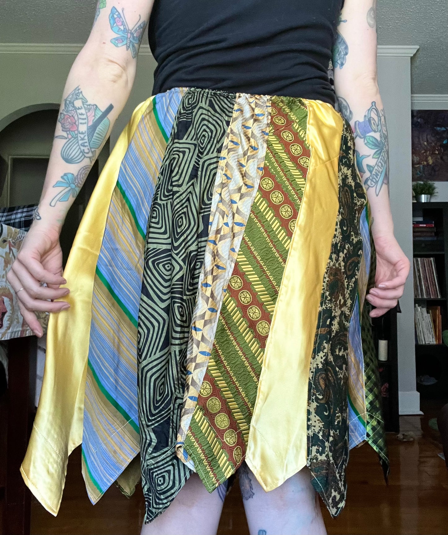 Green and yellow necktie skirt, back view, modeled and held out to the side