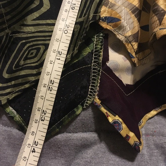 Green and yellow necktie skirt, closeup of measuring tape which reads 24 inches