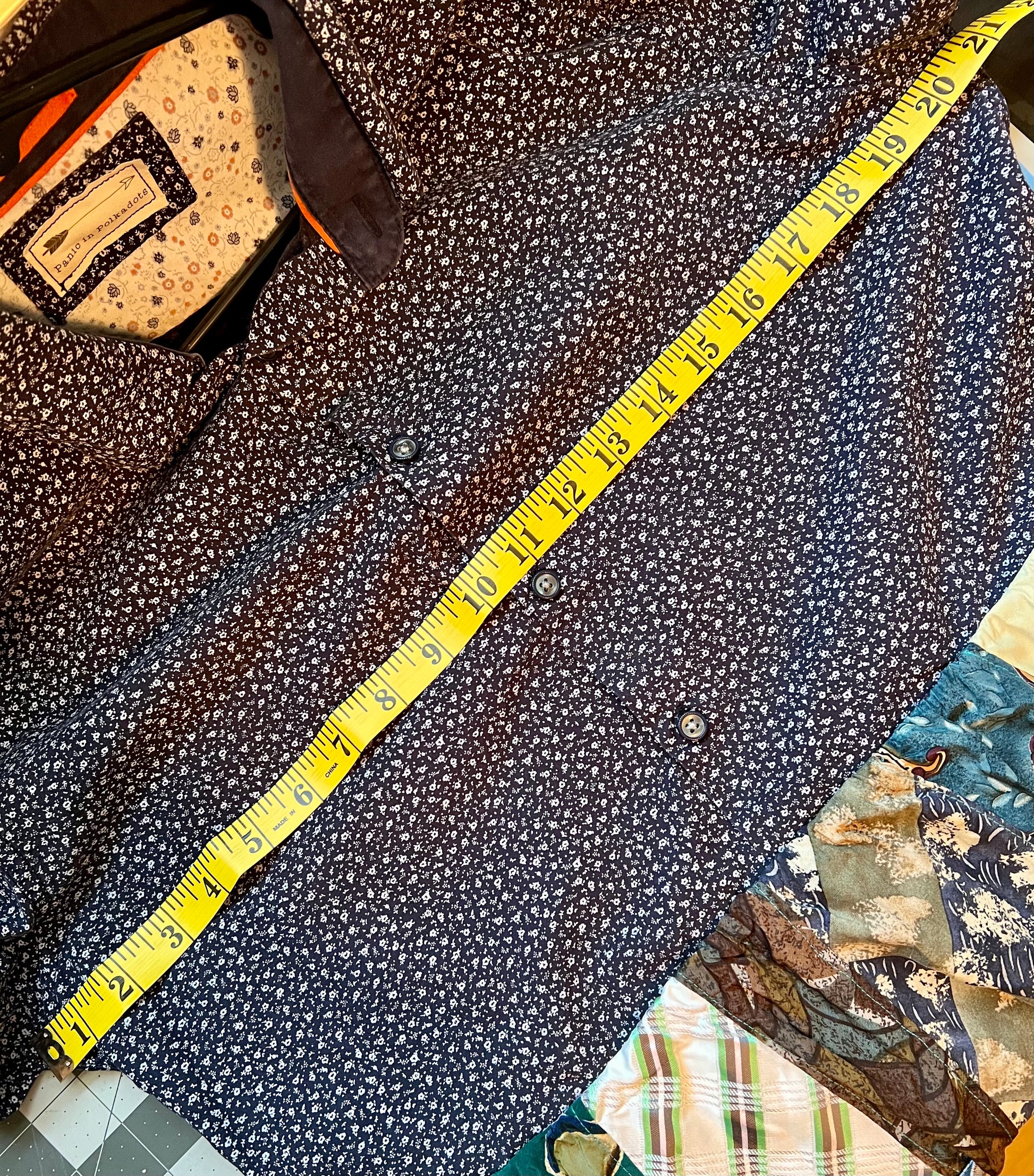 Blue/green shirtdress, with measuring tape across chest (pit to pit), showing 20 1/2 inches.