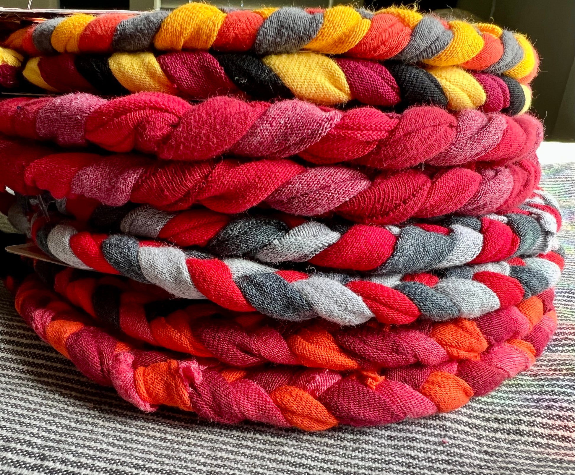 A stack of warm colored trivets, side view.