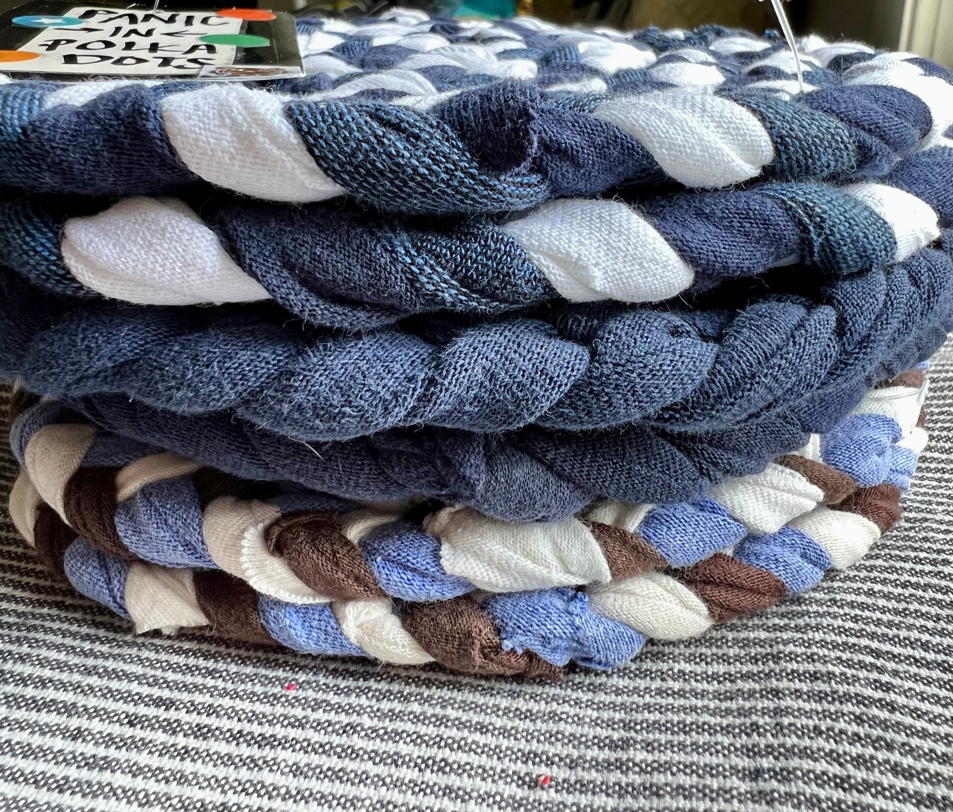 A stack of Navy, blue, and white trivets, side view.