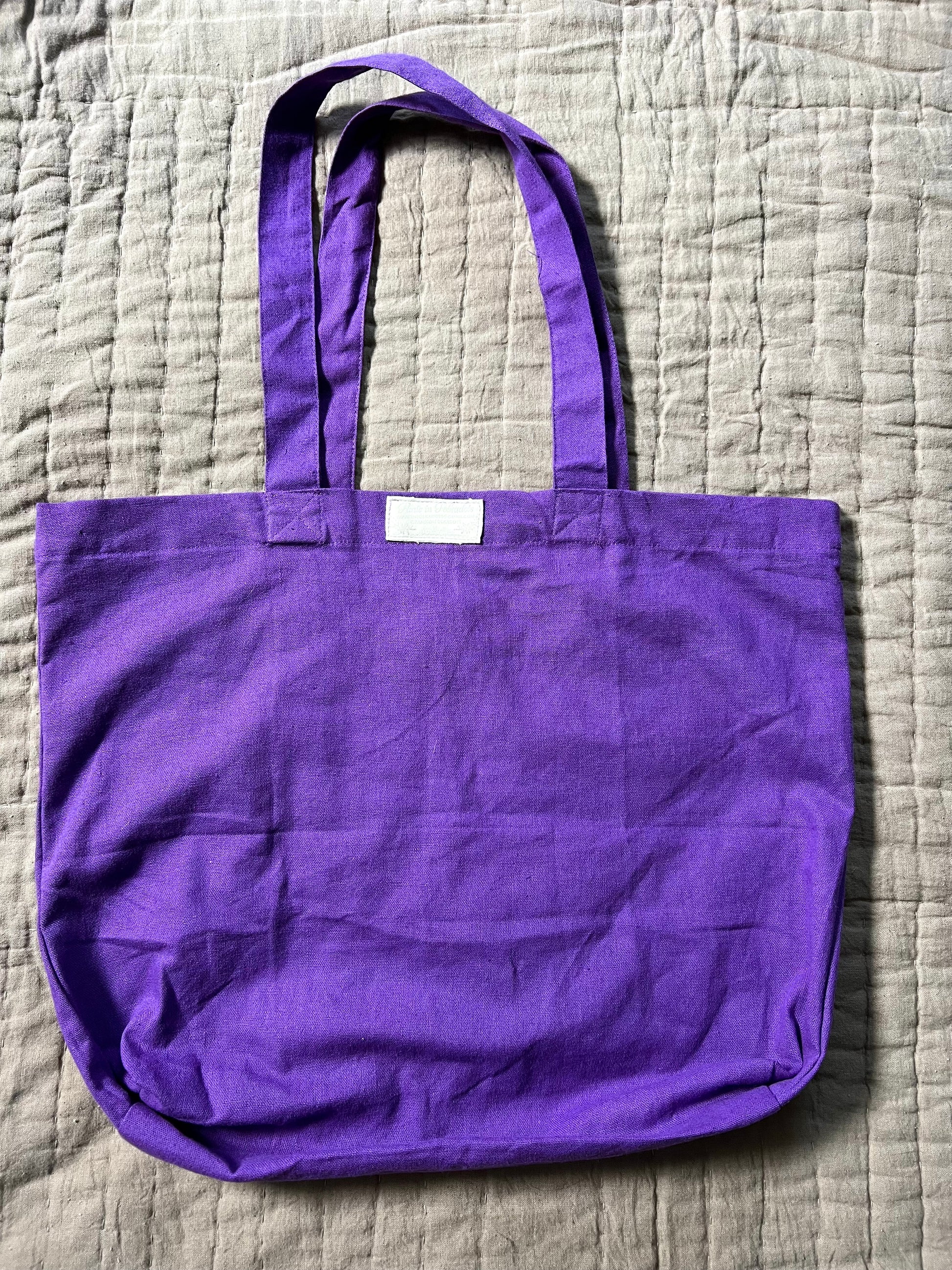 backview of purple tote bag, with Panic in Polkadots label