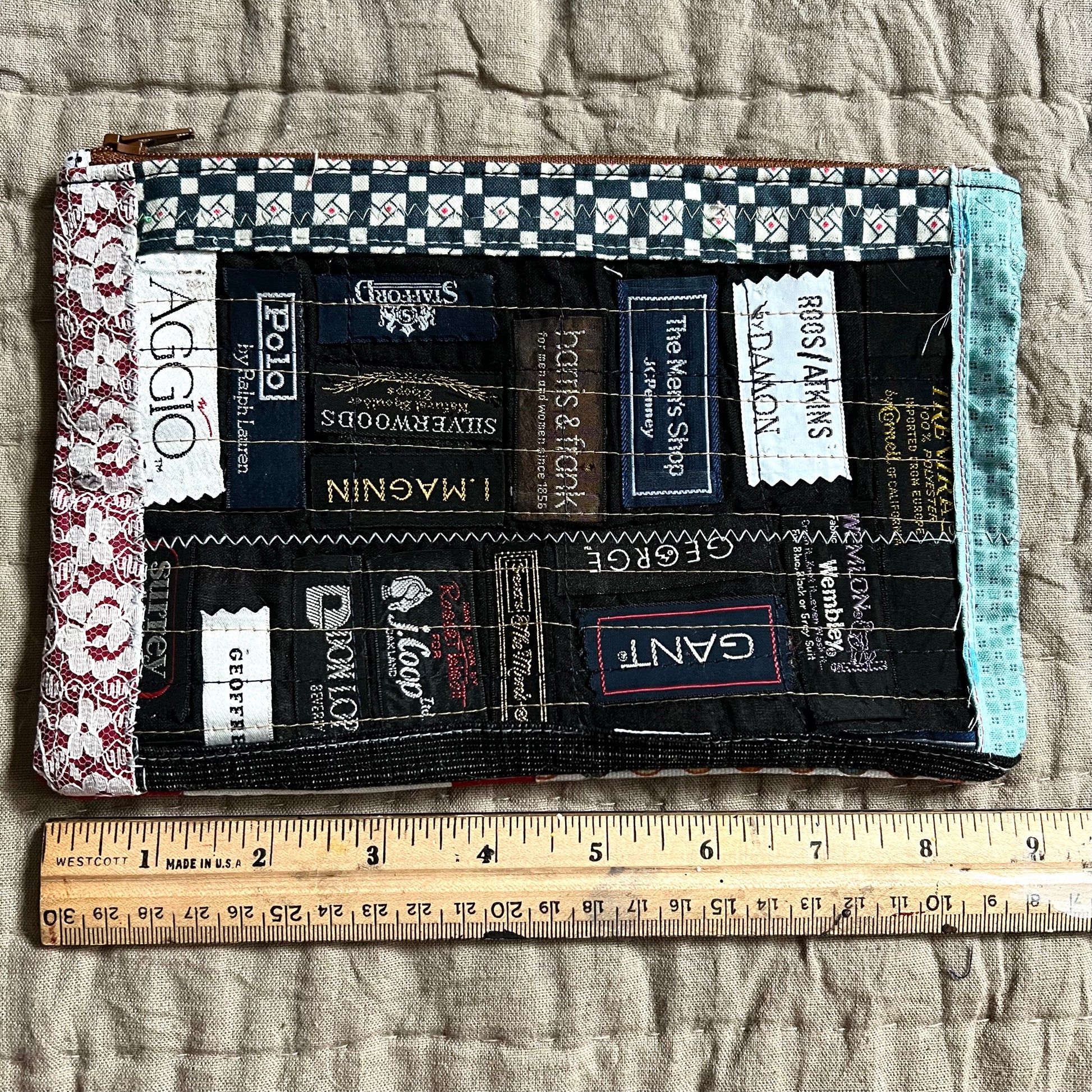 Front view of necktie label zipper pouch, with a ruler underneath which indicates 9 inches
