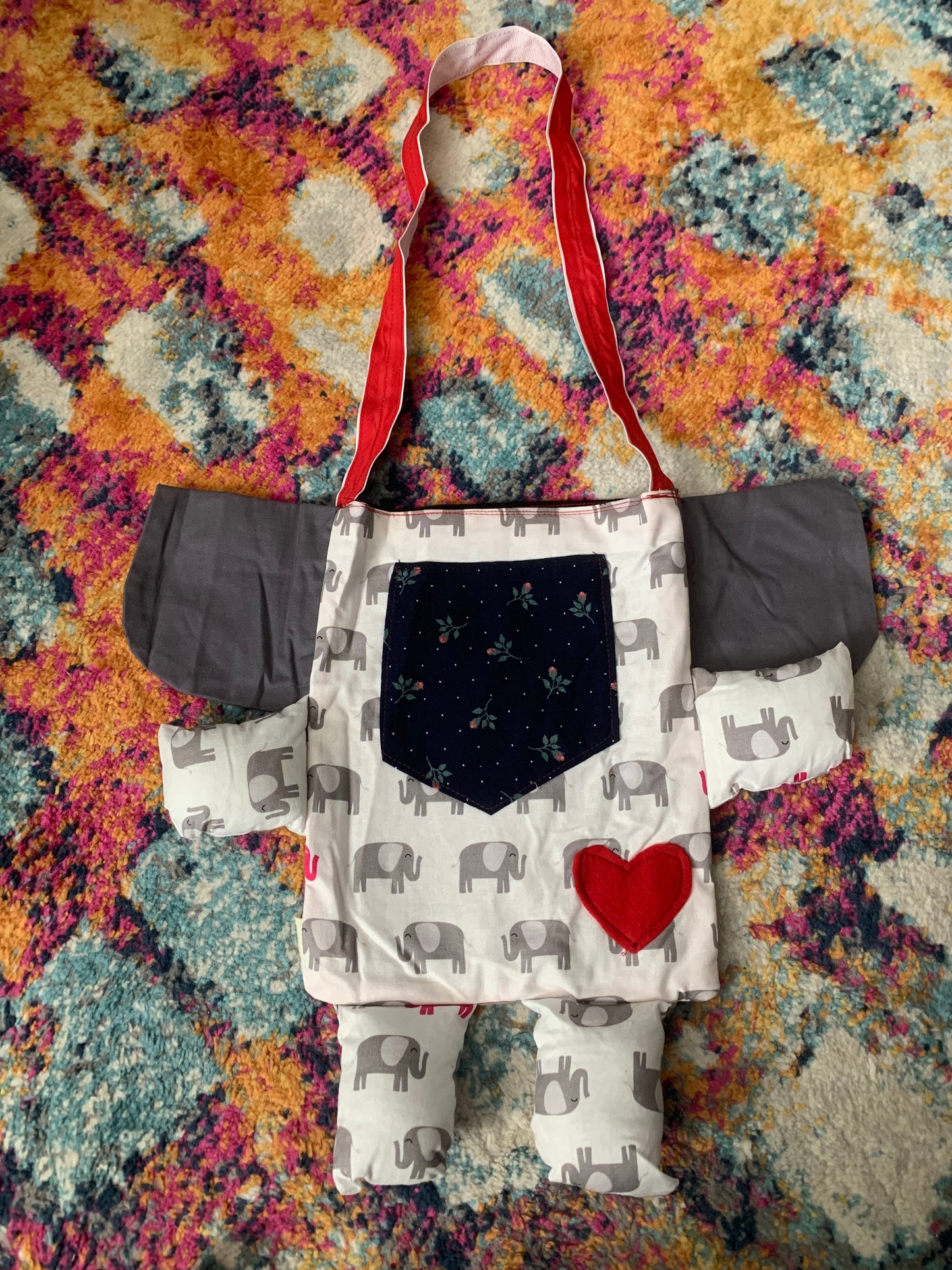 back view of elephant tote bag. a red heart on its bum, and a navy floral print pocket