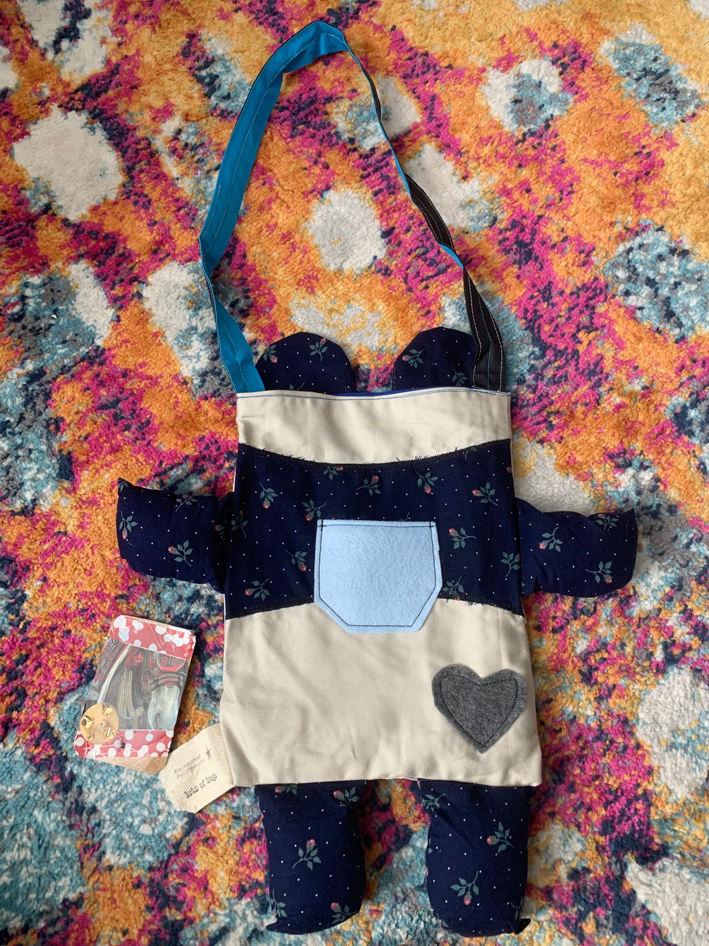 back view of panda bear tote bag, with a small blue pocket, and a grey heart on its bum.