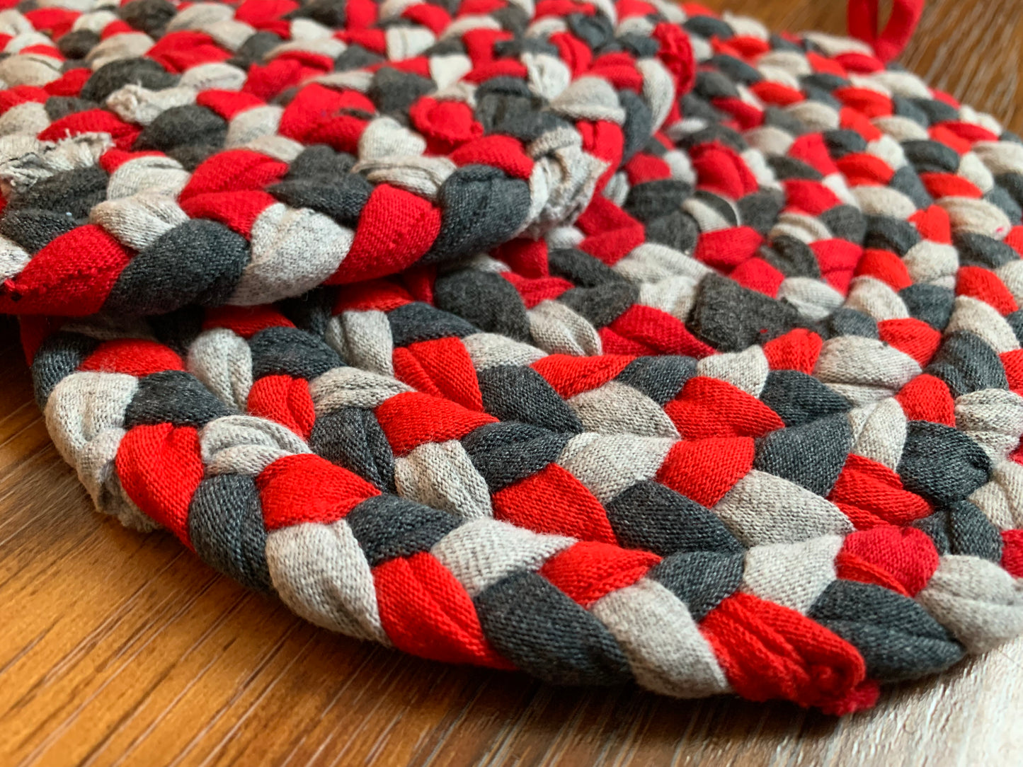 Close up, side view, showing detail in edge of trivets on wood surface.