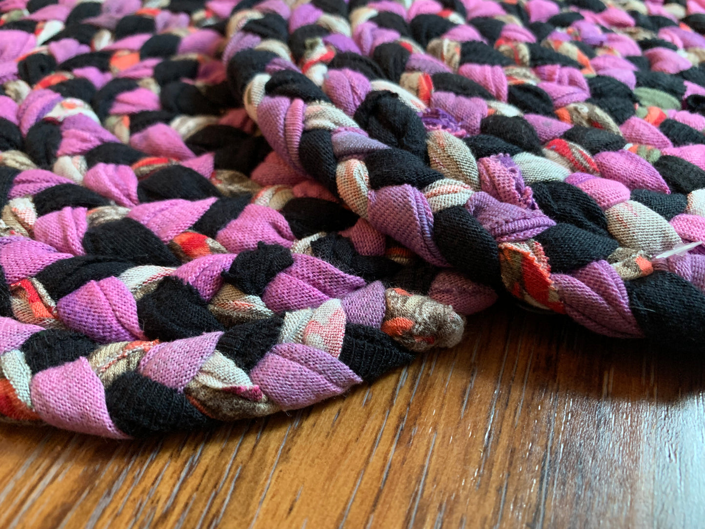 Close up, side view, showing detail in edge of trivets on wood surface.