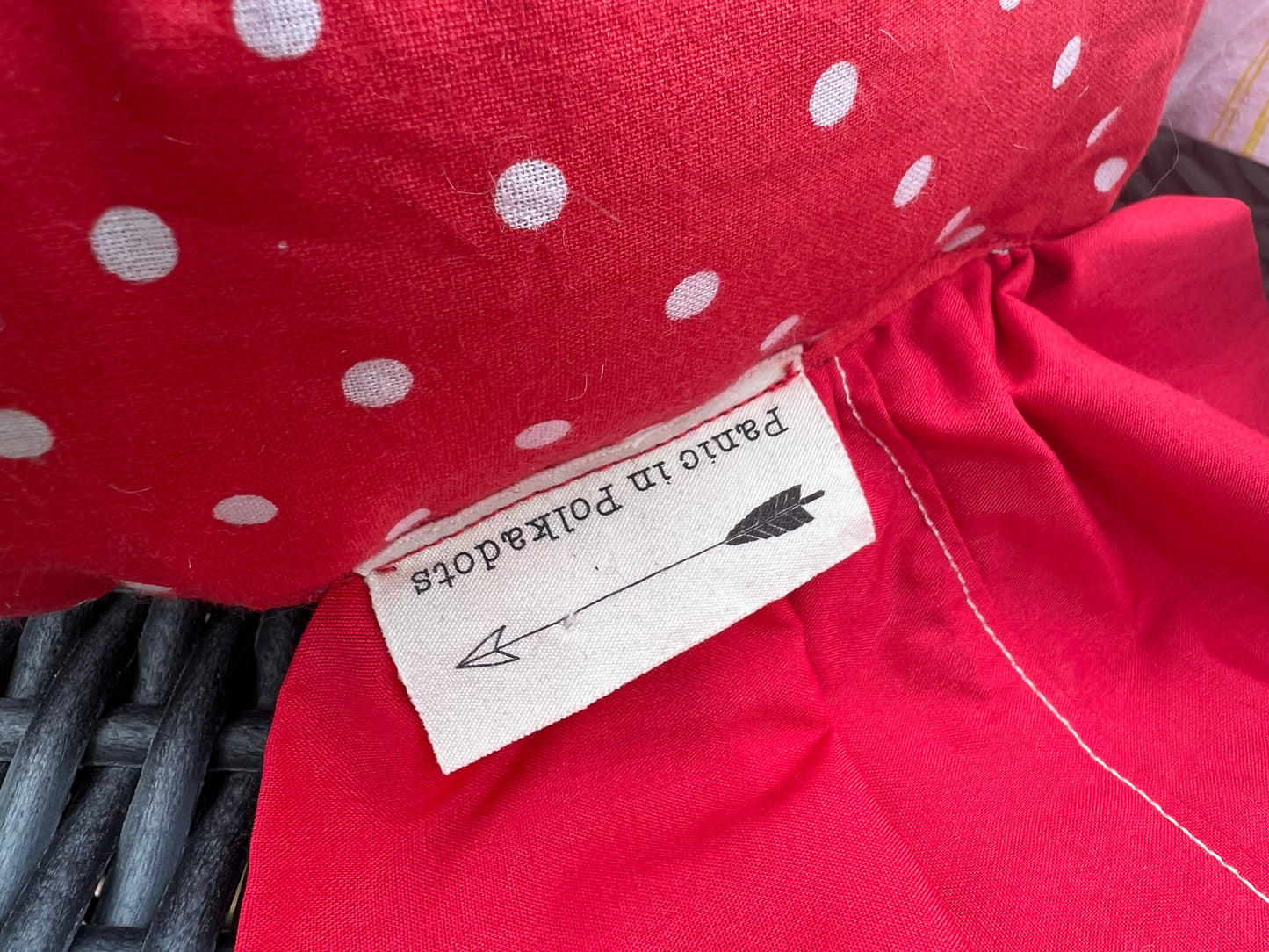 "Panic in Polkadots" label, closeup view, as it is shown sewn into the "wrap" part of candy pillow