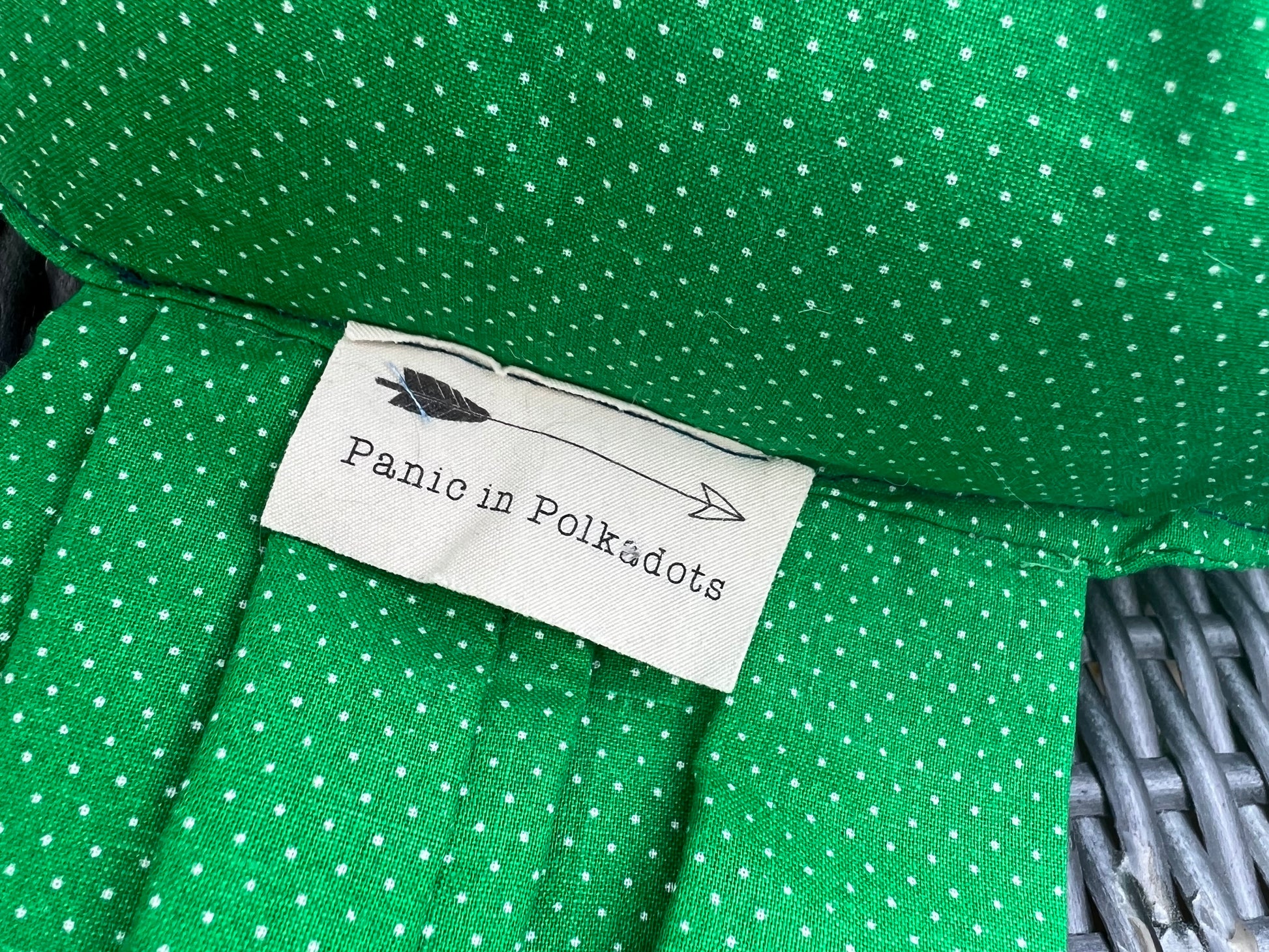 "Panic in Polkadots" label, closeup view, as it is shown sewn into the "wrap" part of candy pillow