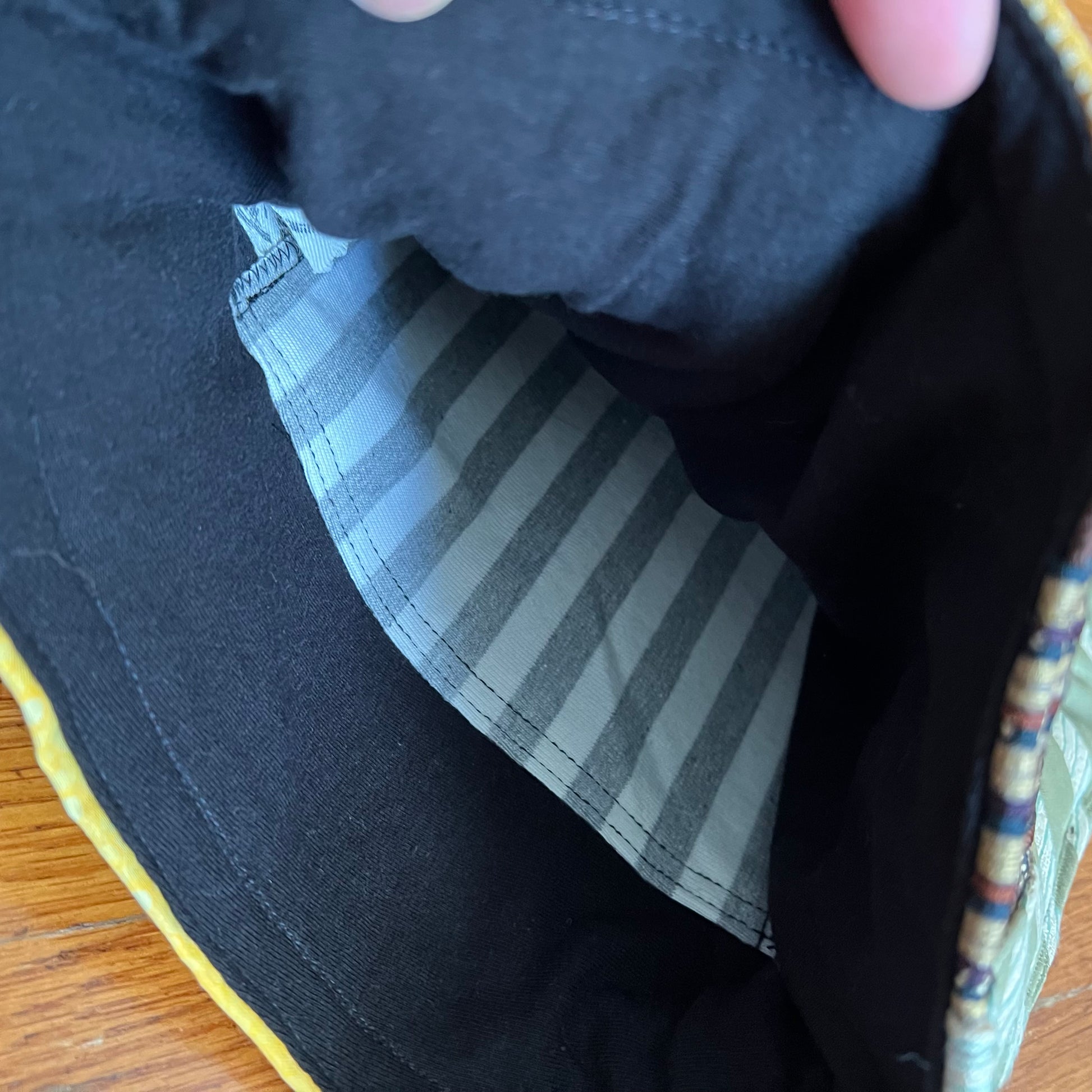 Inside of tote bag, showing a soft tshirt interior with a striped pocket. Panic in Polkadots label.