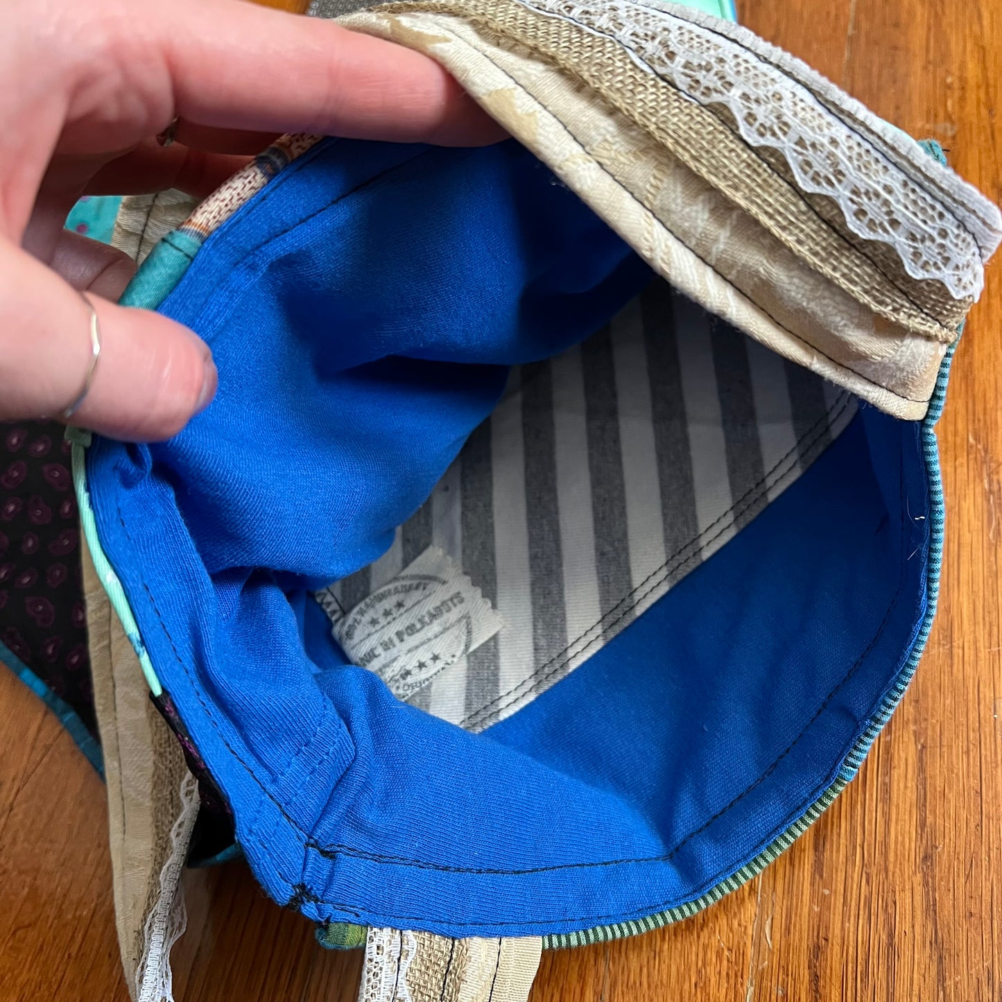 Inside of tote bag, showing a soft tshirt interior with a striped pocket. Panic in Polkadots label. 