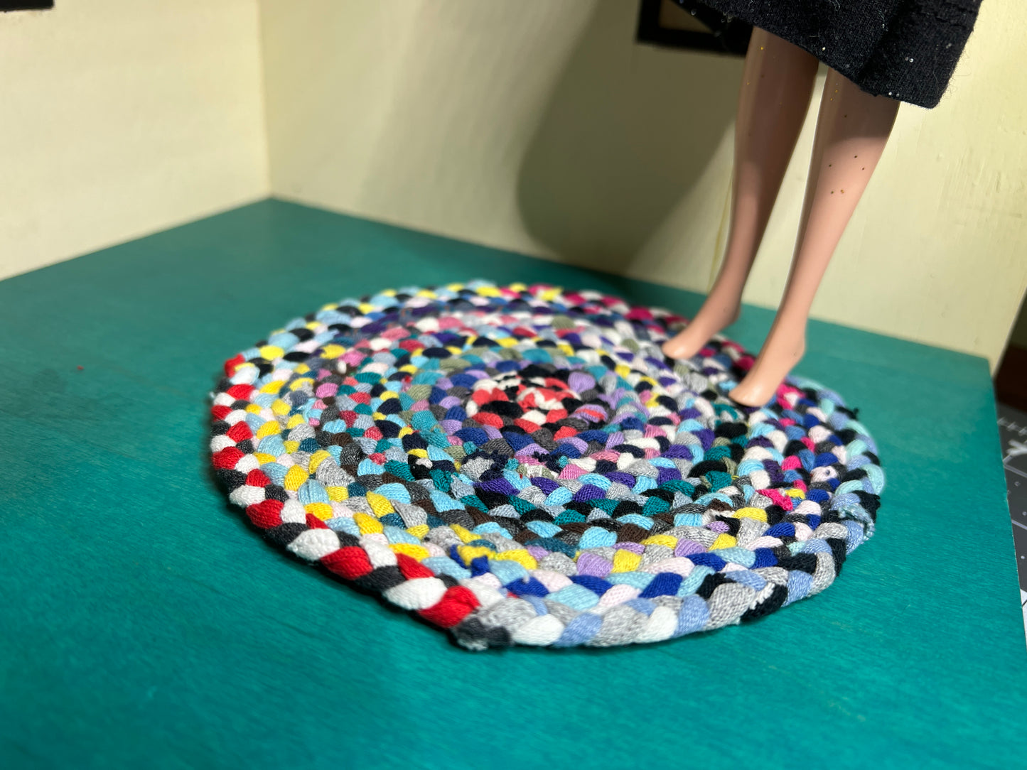 view of miniature rug in a room box, with Barbie standing atop the autumn colors rug for scale and display ideas