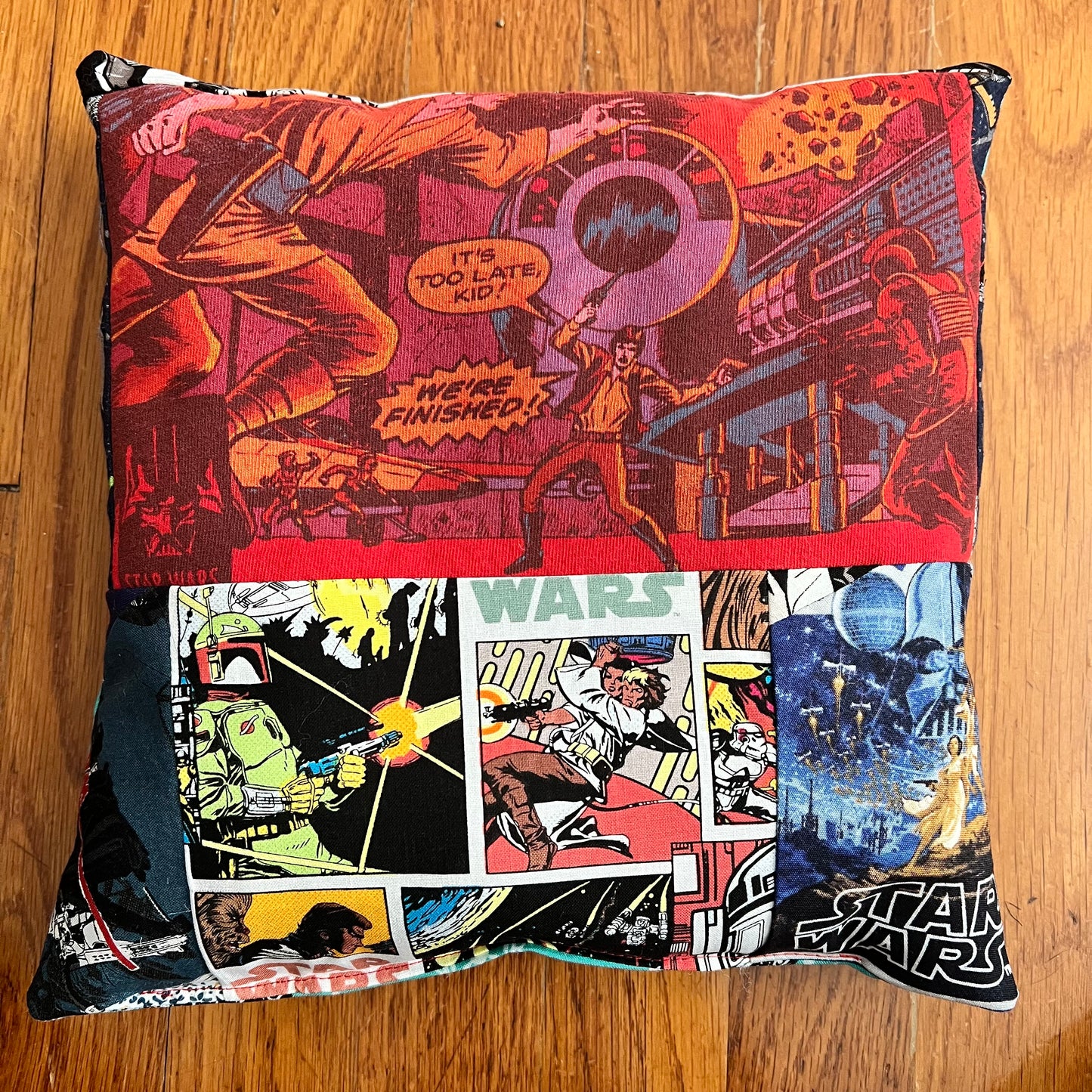 A little accent pillow with Star Wars comic book print on a red tshirt, and various star wars comic scenes below