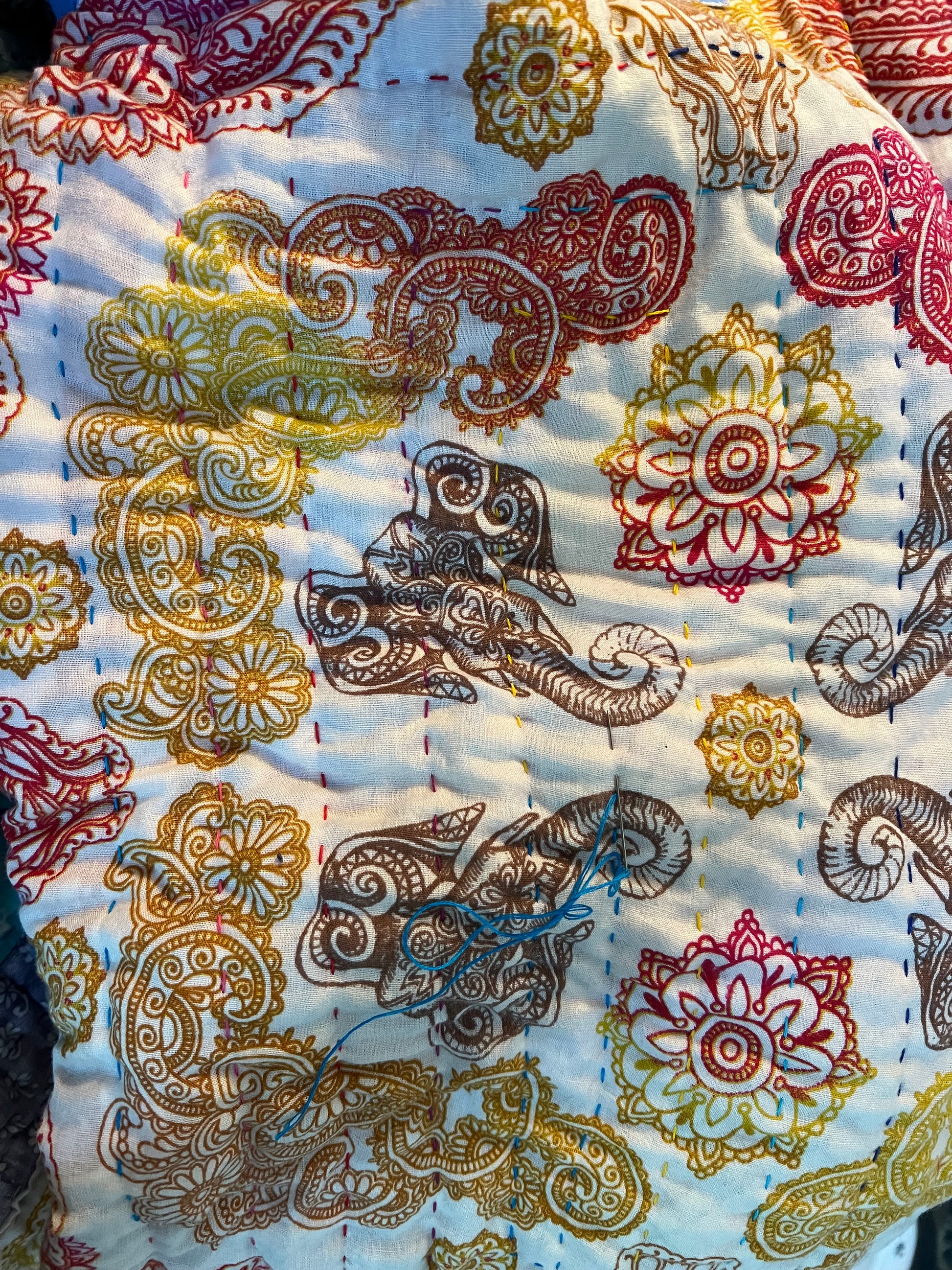another closeup of hand stitching, this is a bandana with elephants and filigree design
