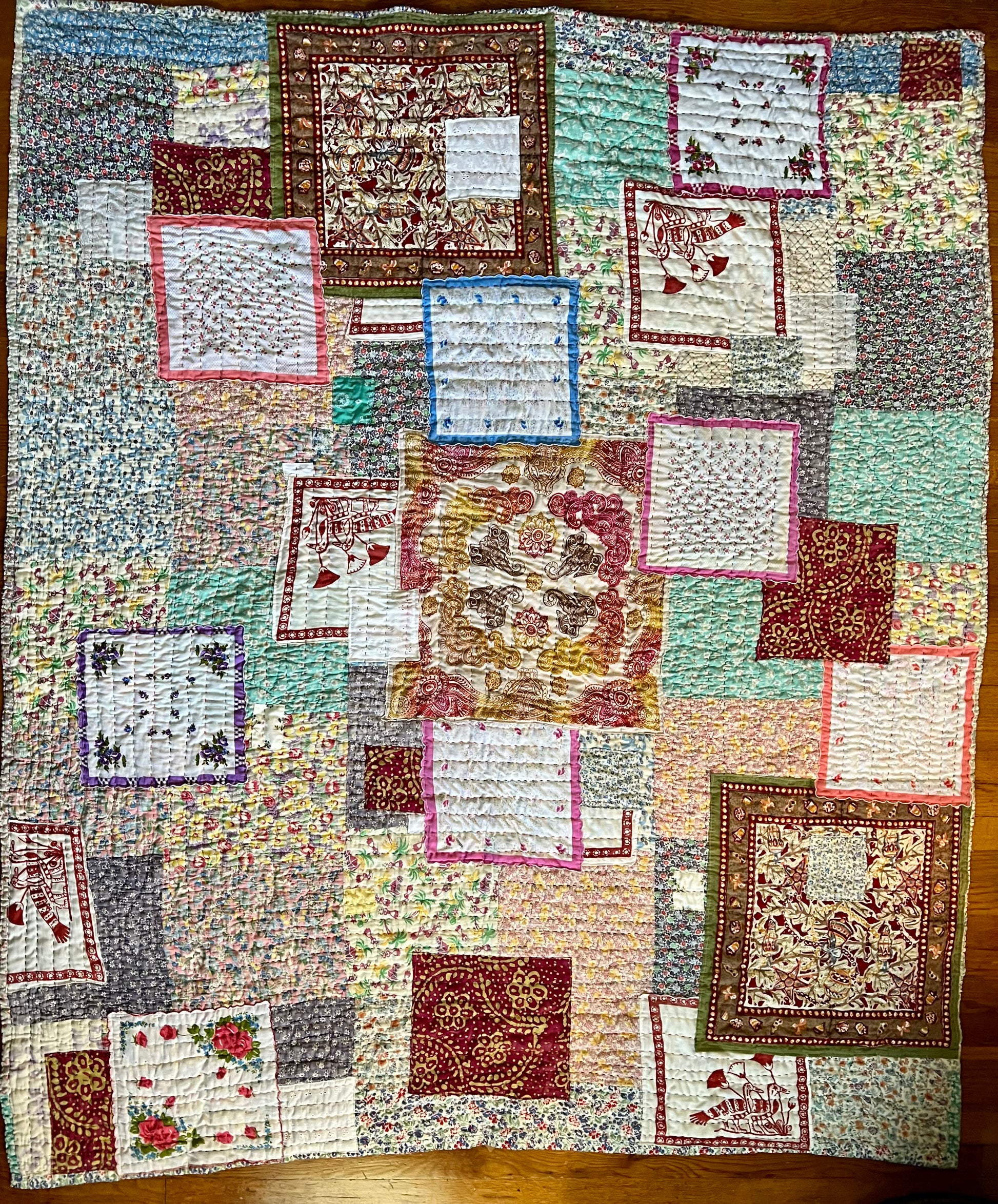 aerial view of this twin sized, extra heavy quilt, against a wood floor background