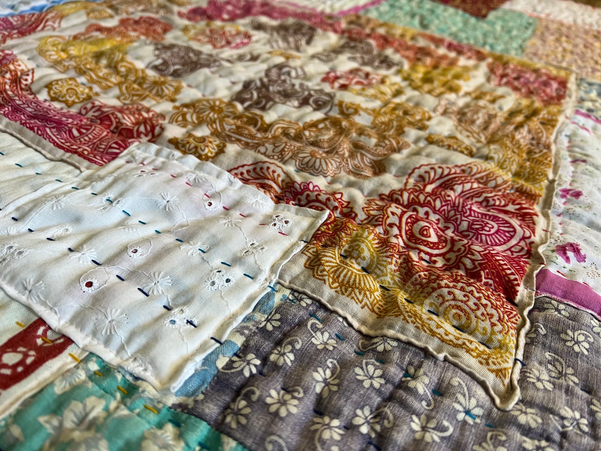 extra closeup view of the quilt, with hand-stitching. Handkerchiefs have been layered on top of damaged portions of the very old quilt