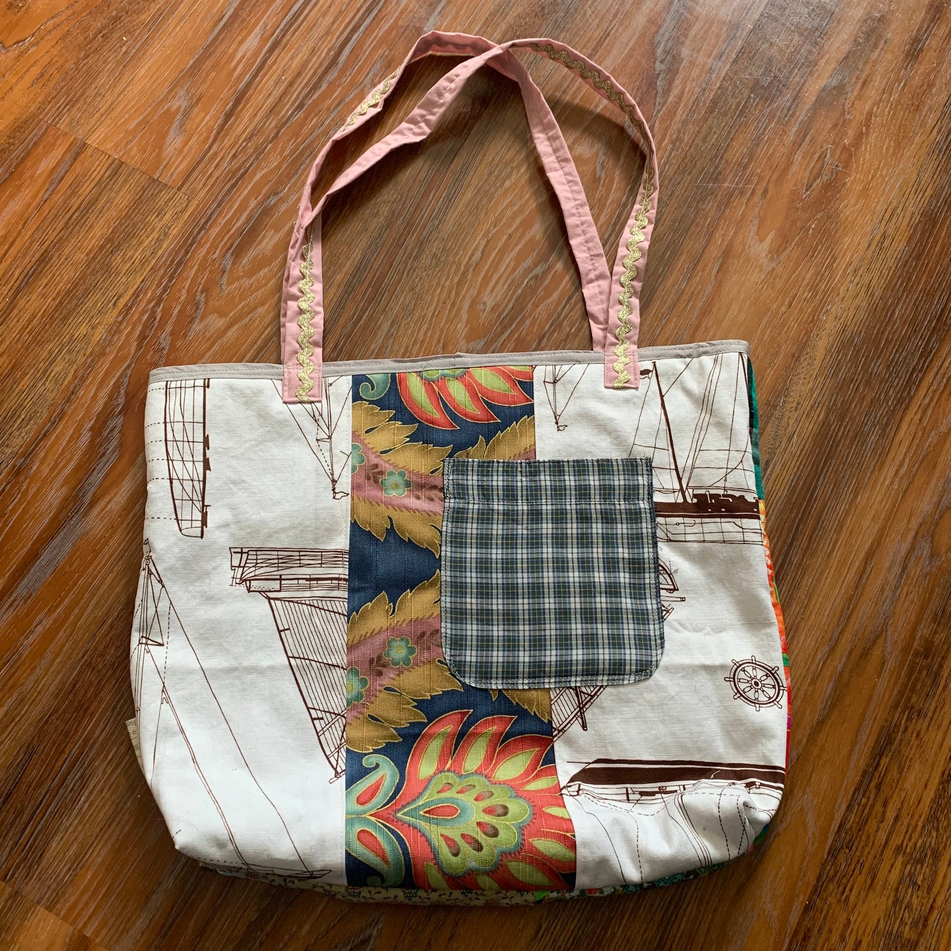 back view of perfectly imperfect tote bag, with pocket detail, against a wood background