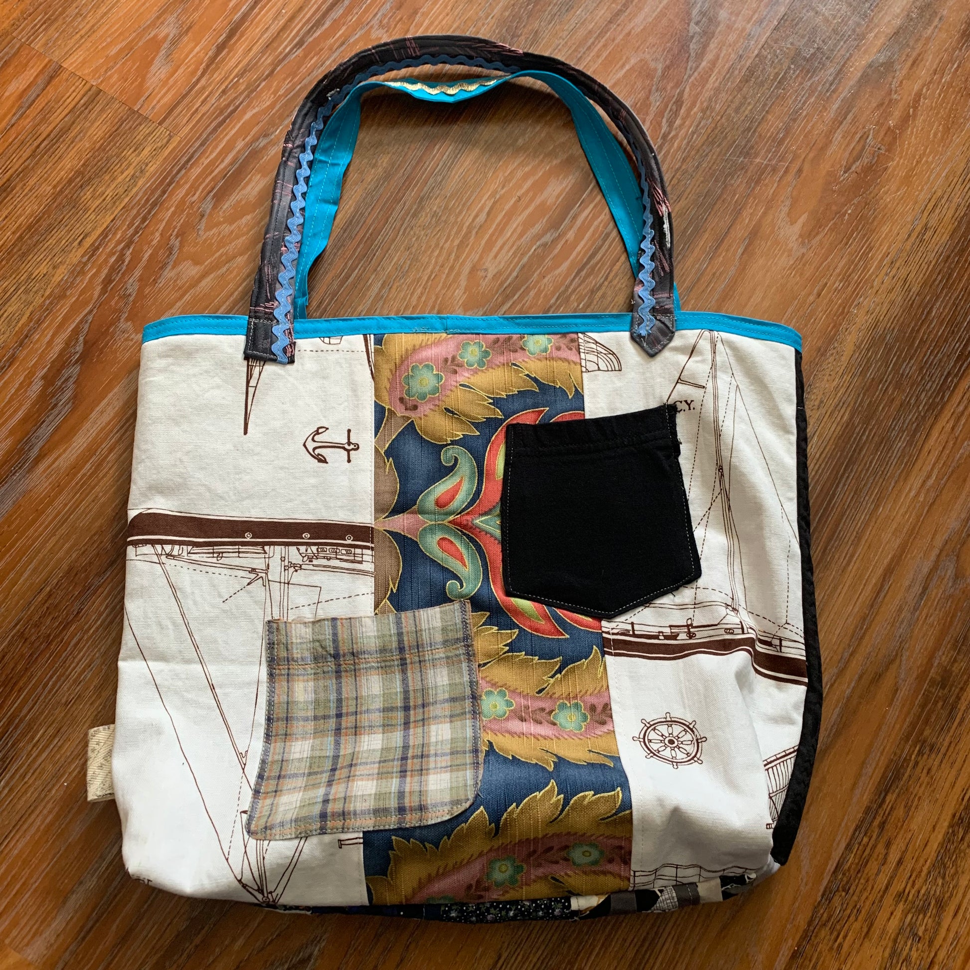 back view of perfectly imperfect tote bag, with pocket detail, against a wood background