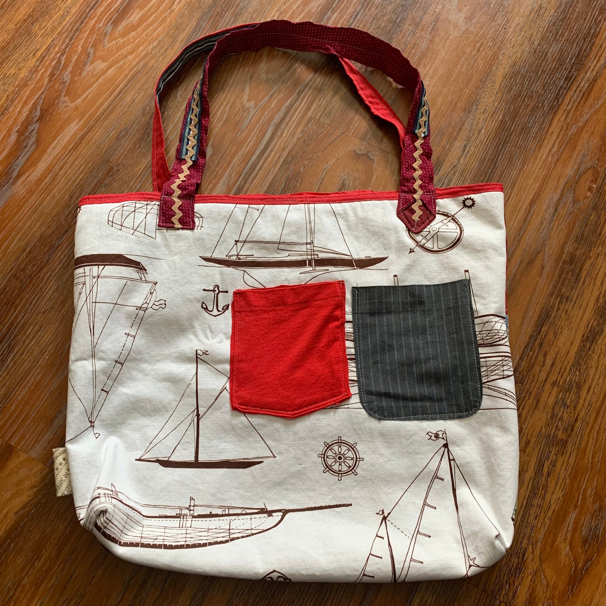 back view of perfectly imperfect tote bag, with pocket detail, against a wood background