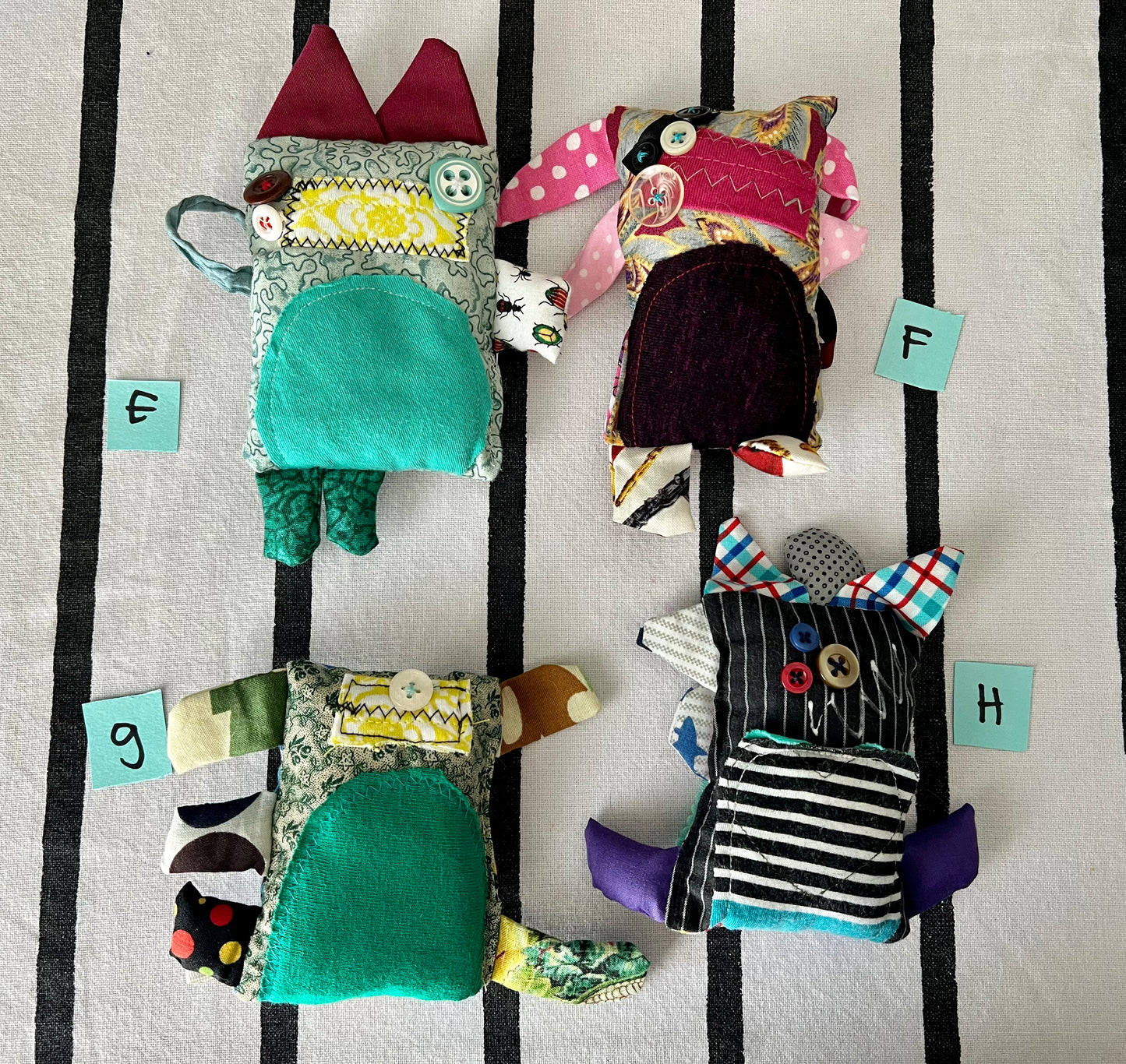 front view of mini monsters with letters E F G H next to each one.