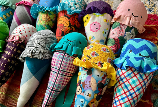Colorful fabric cones with various patterns and designs on a textured surface