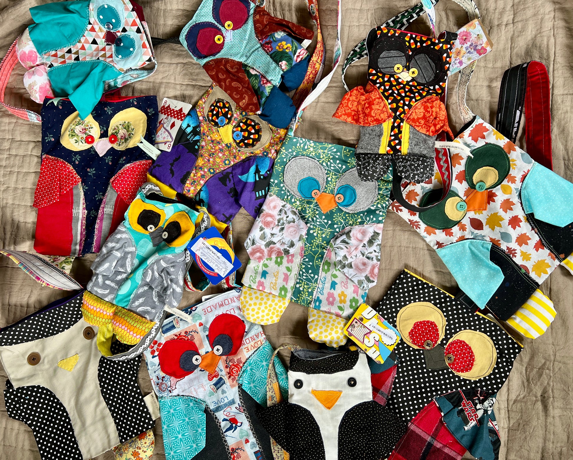 Owl and penguin tote bags assorted in an array on a neutral quilt background