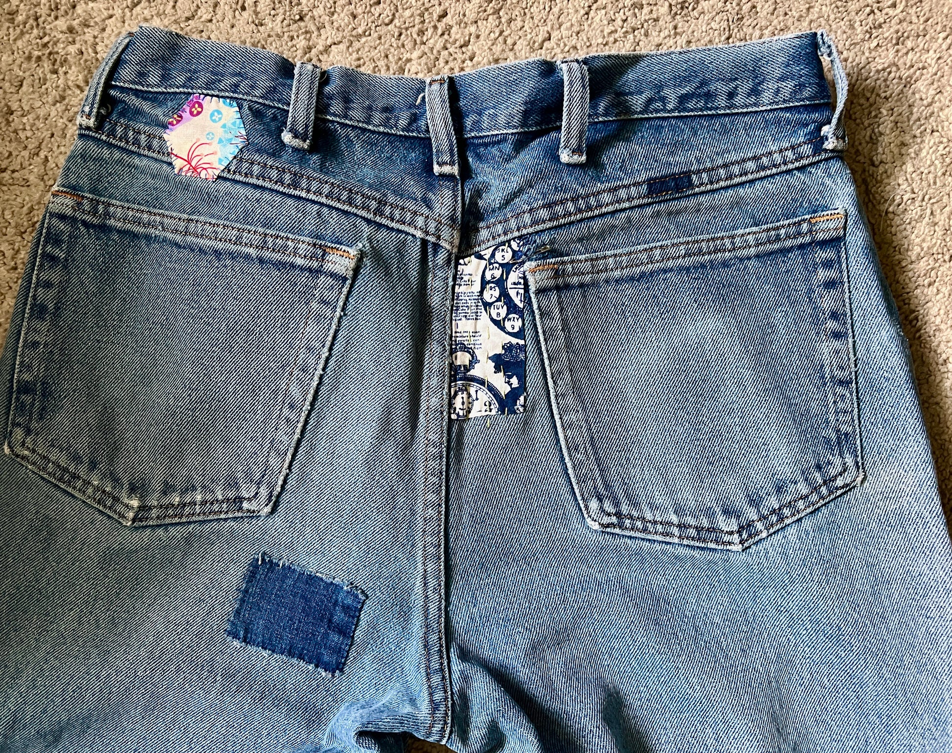 Panic clothing, denim jeans with blue advertisement fabric added to prolong their life