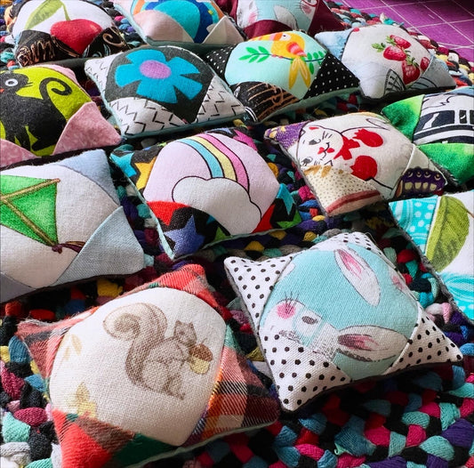 Collection of colorful fabric pillows with various patterns and designs.