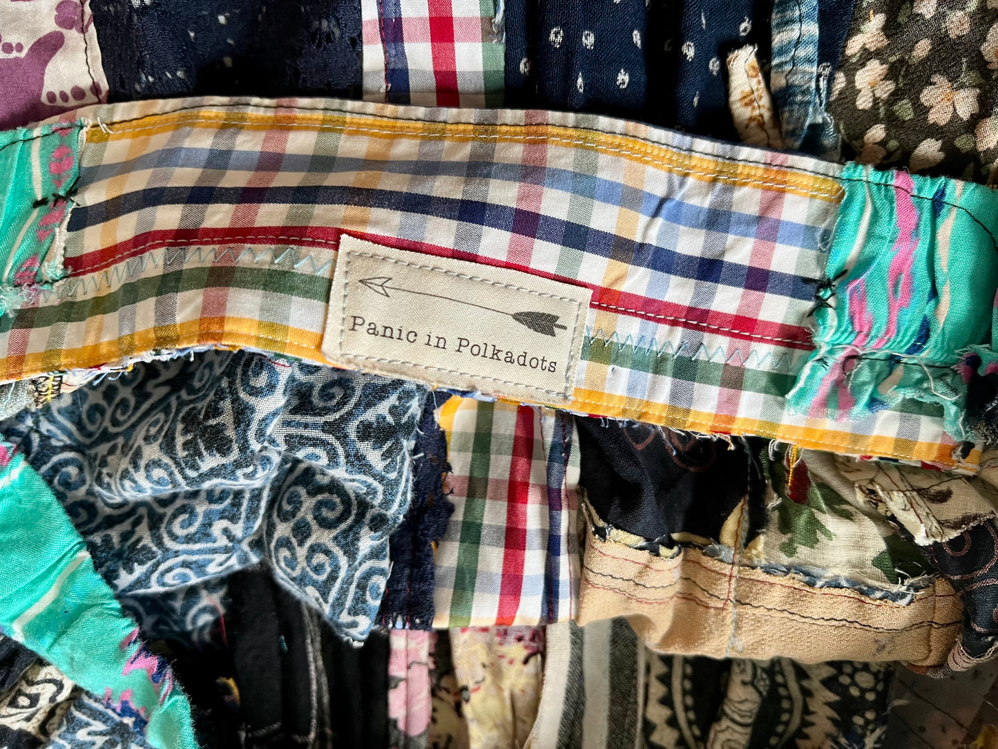 Colorful fabric with a label reading 'Panic in Polkadots' among other patterned fabrics.