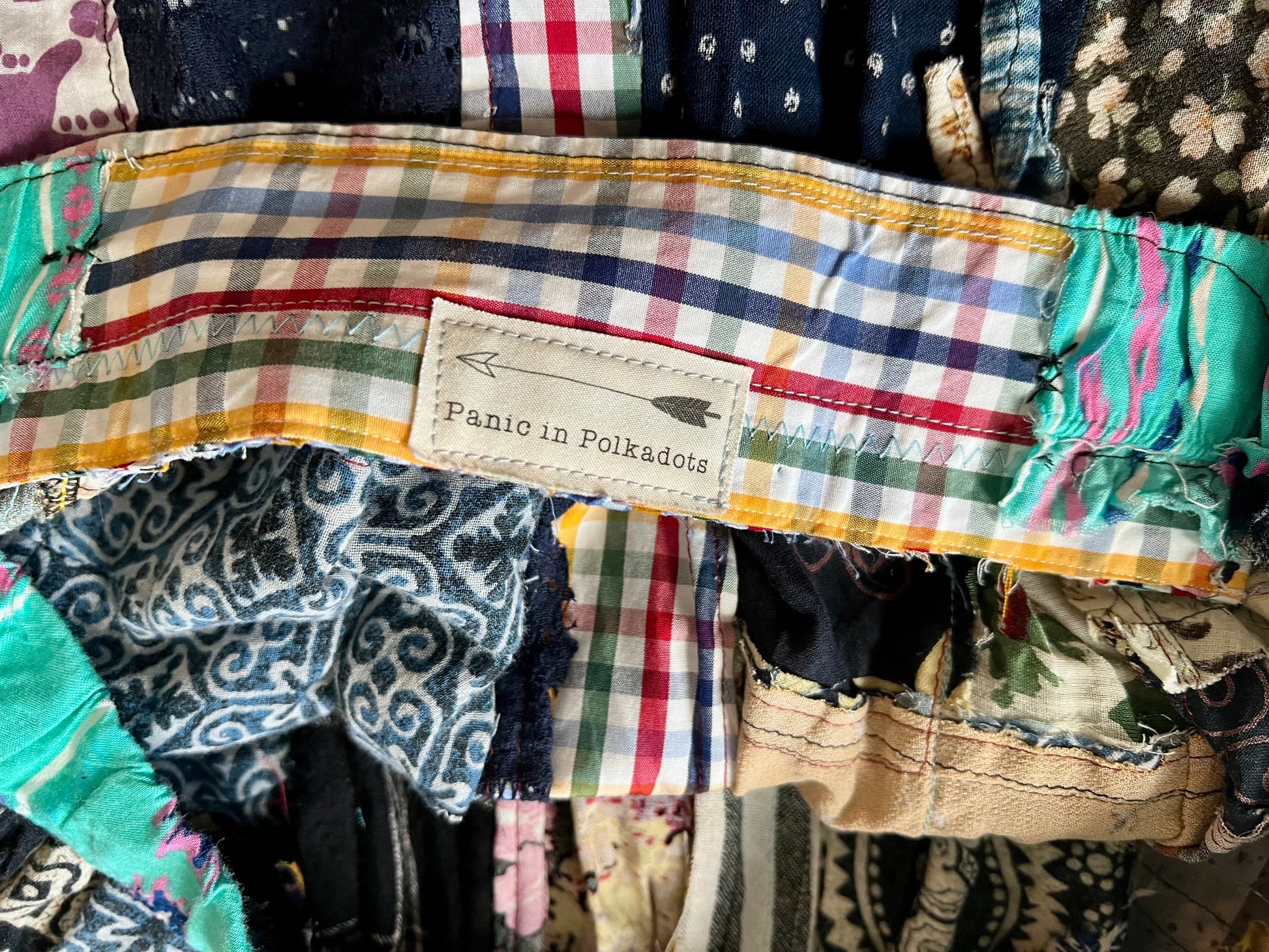 Colorful fabric with a label reading 'Panic in Polkadots' among other patterned fabrics.