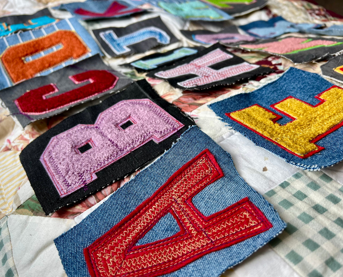 Collection of colorful embroidered patches on a checkered fabric background