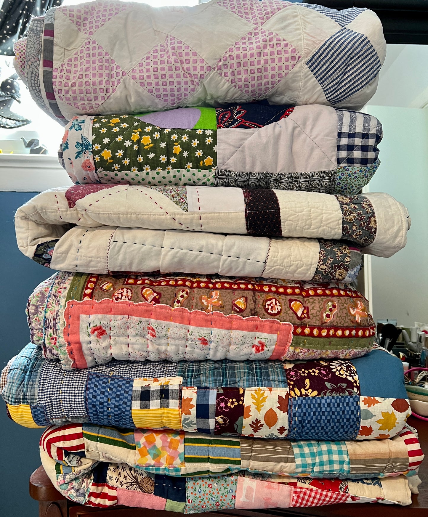 Stack of colorful patchwork quilts on a table