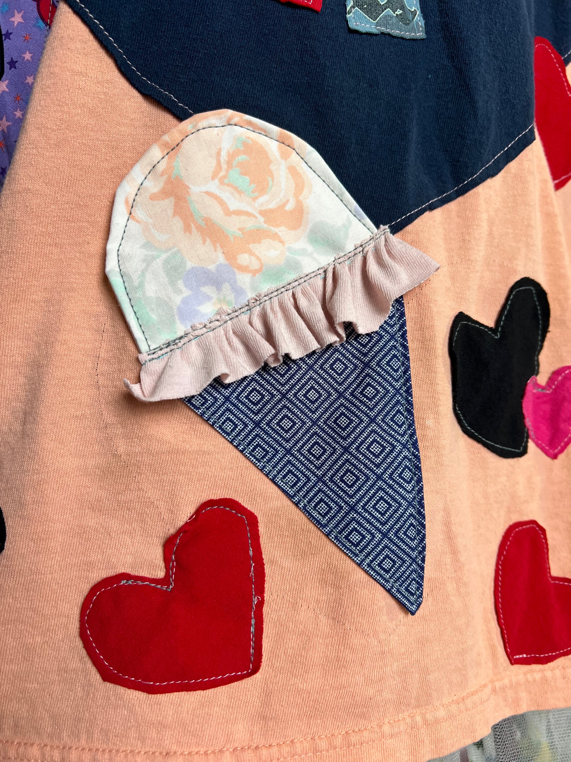 Close-up of a patchwork quilty tee with heart shapes and ice cream cone patterns.