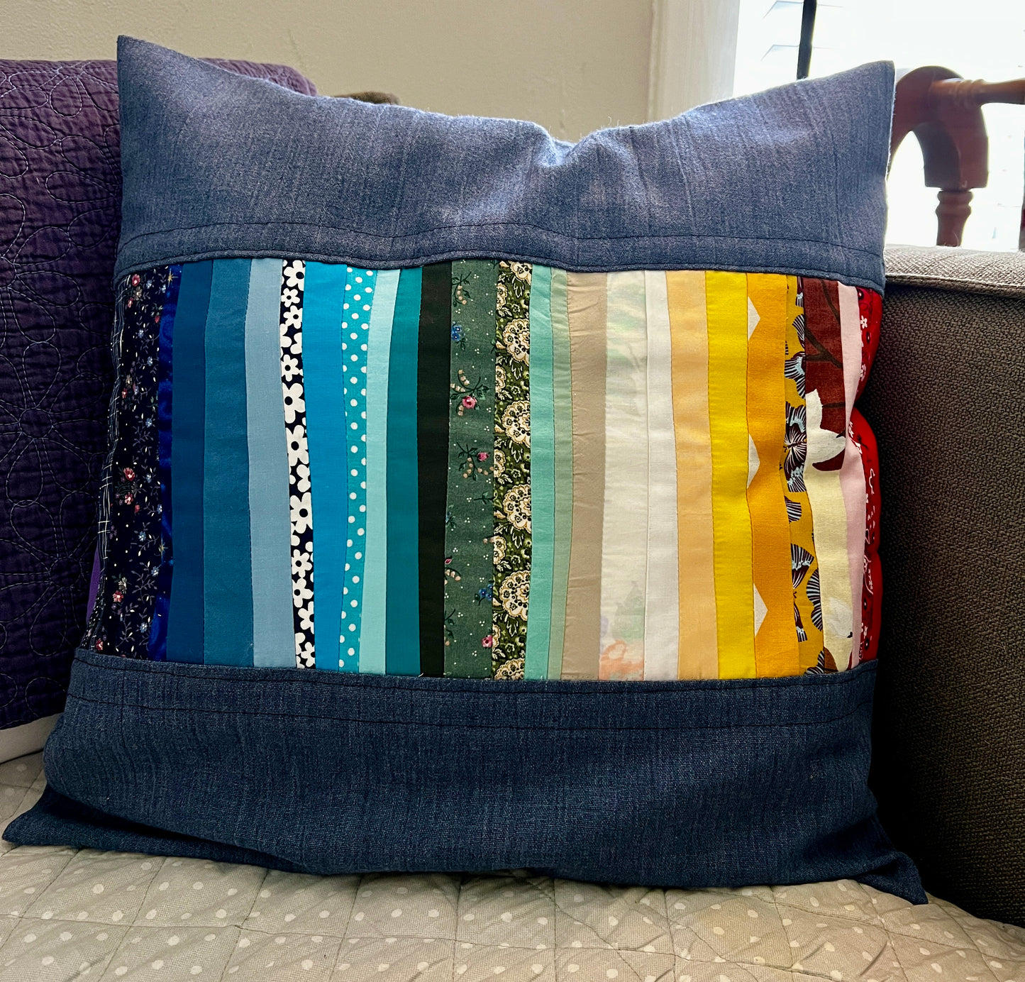 a vibrant rainbow across the middle of this denim linen pillow cover
