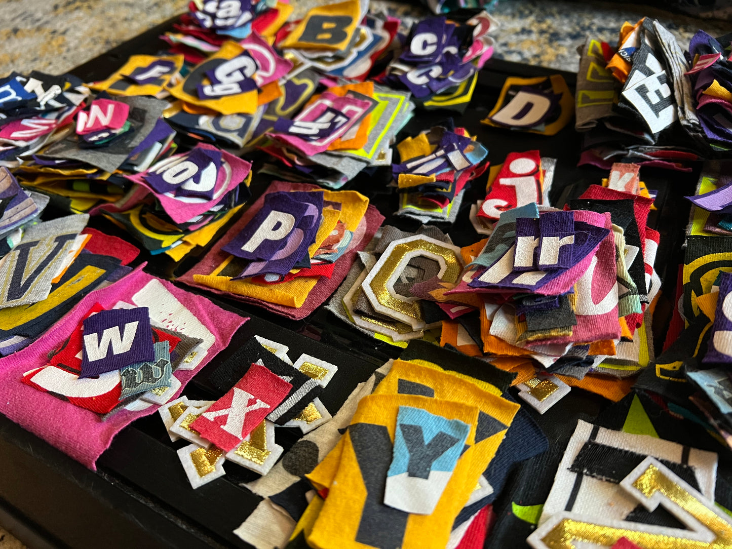 Collection of colorful letter patches on a dark surface