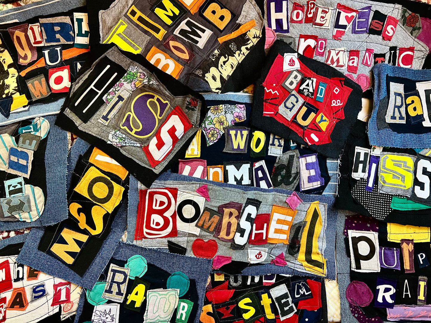 Collection of colorful fabric patches with various words and phrases.