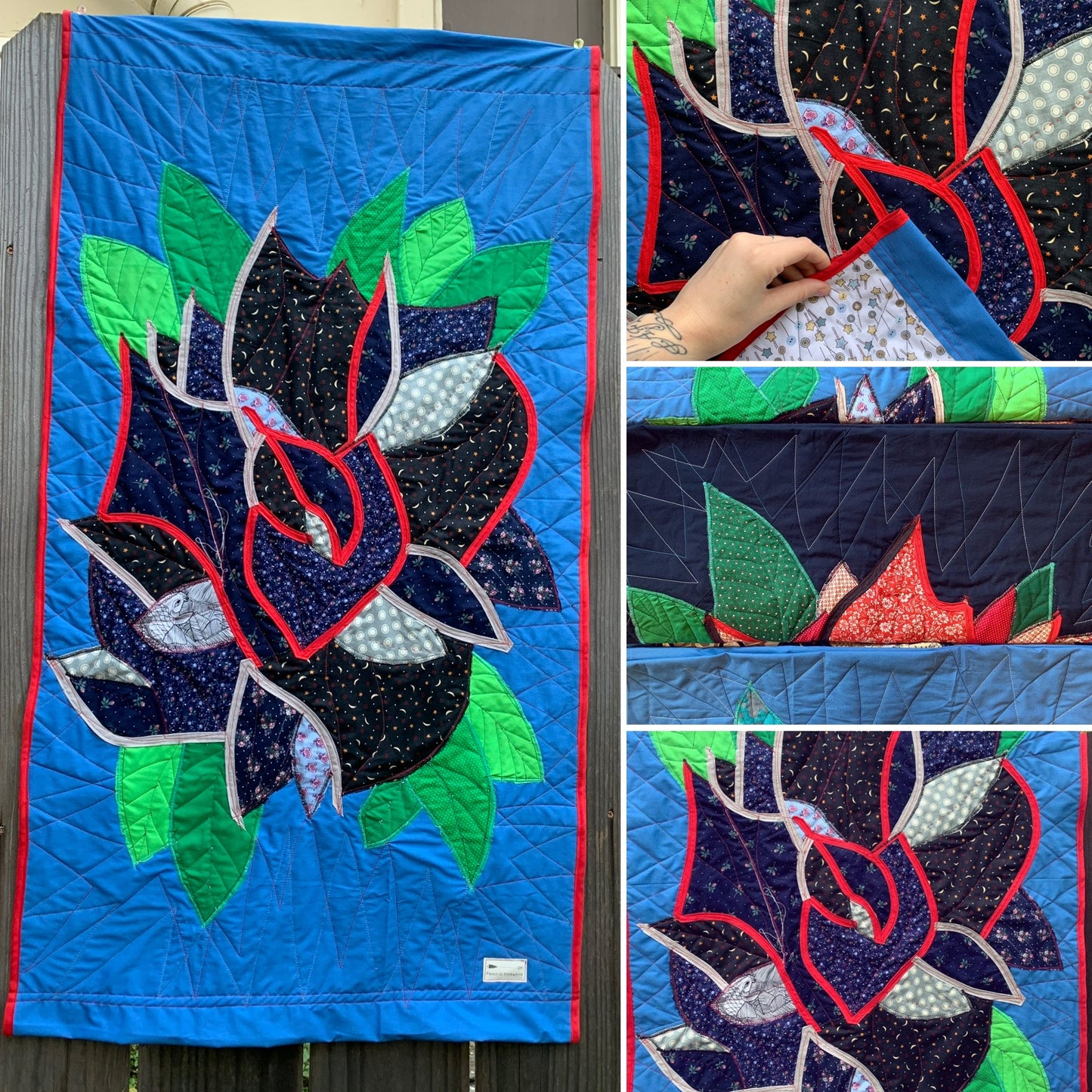 Quilt with black and navy floral rose design on a blue background, showing close-up details.