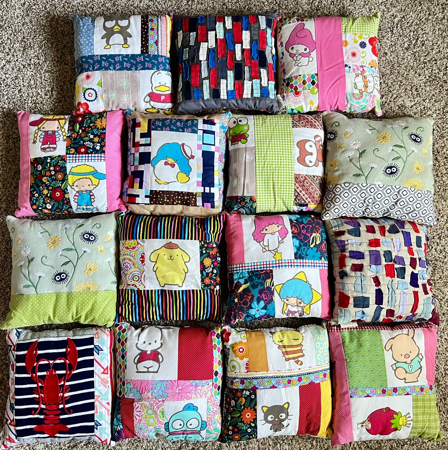 A collection of 15 handmade patchwork little pillows arranged in a grid on a beige carpet. Each quilt features various colorful patterns, including stripes, florals, cartoon characters, and solid colors.