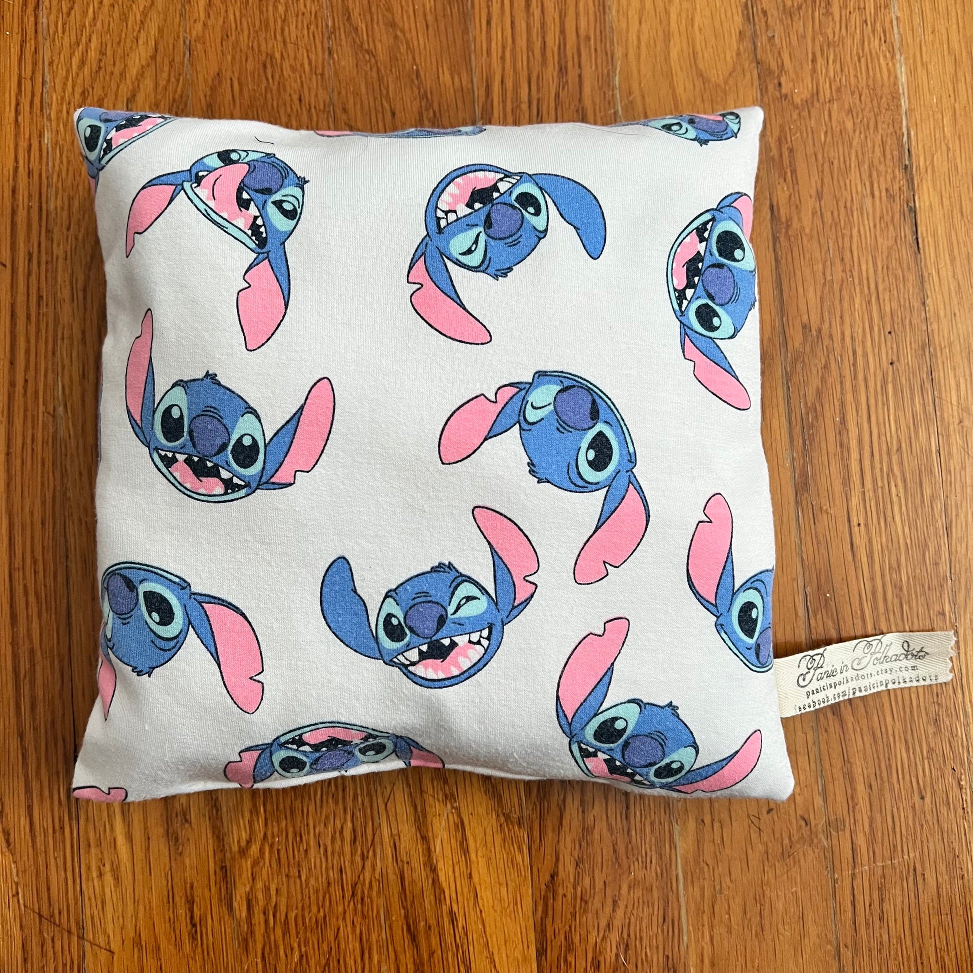A little tooth fairy pillow featuring stitch from Lilo and stitch, aerial view against a wood background