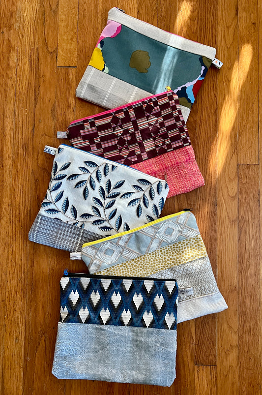 Tablet zipper pouch designer offcuts, assortment in an array on a wood background