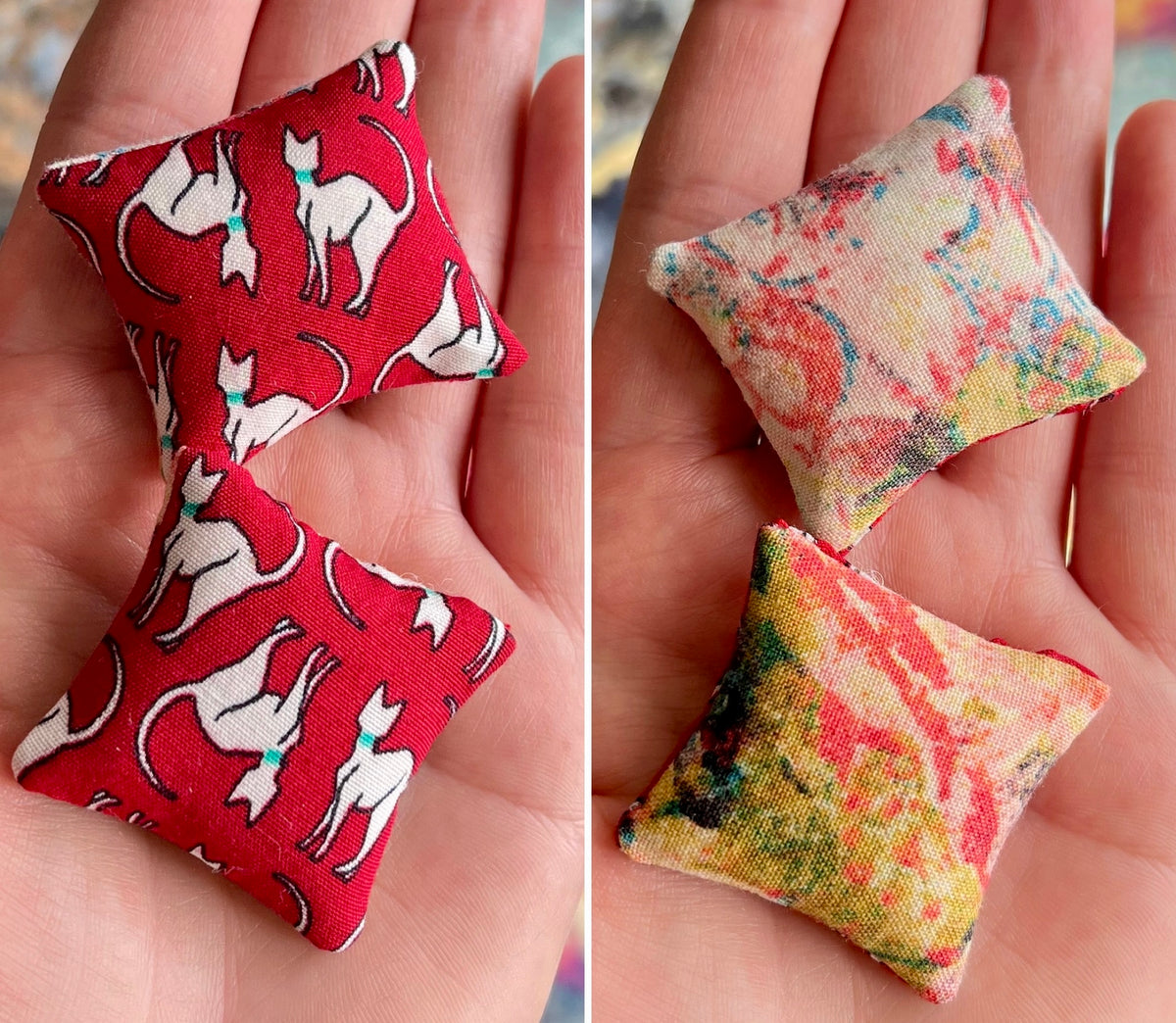 Two sets of small fabric pillows held in hands, front with cat pattern and the back with floral pattern.