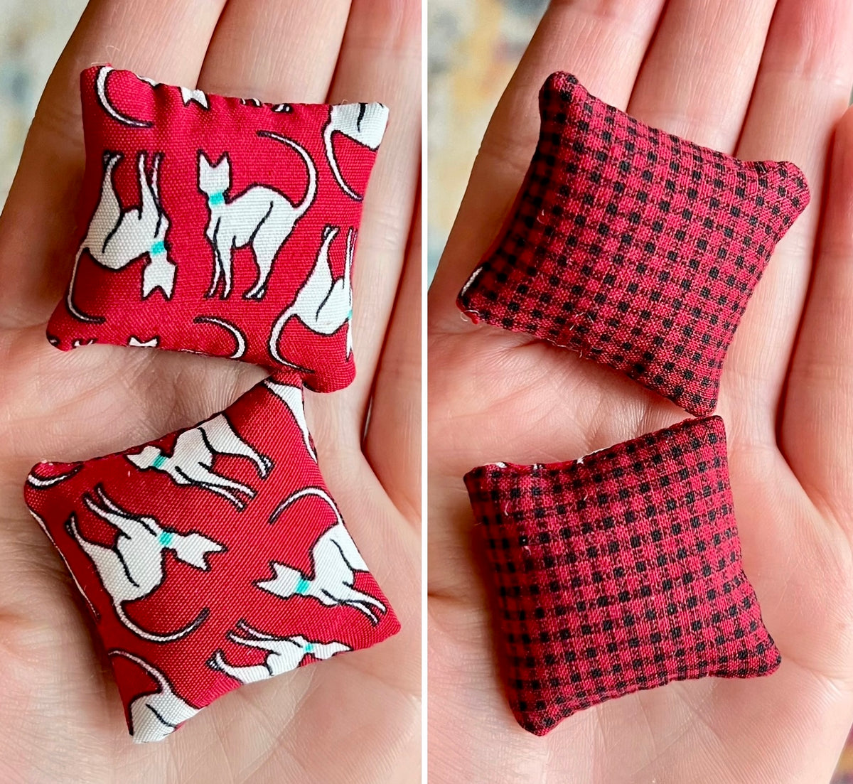 Two red fabric doll pillows with different patterns front and back held in hands.