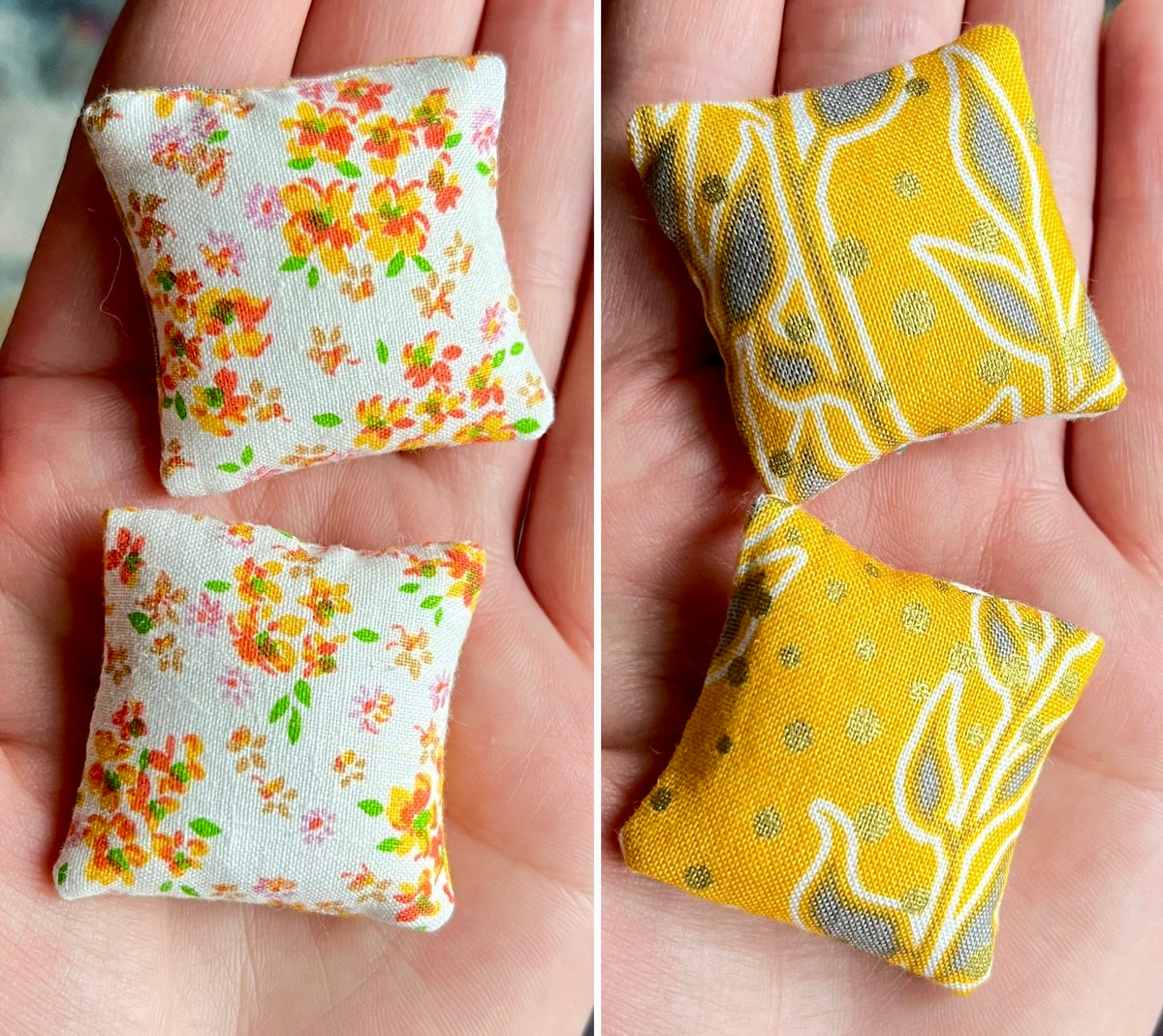Two small fabric pillows with floral patterns held in a hand.