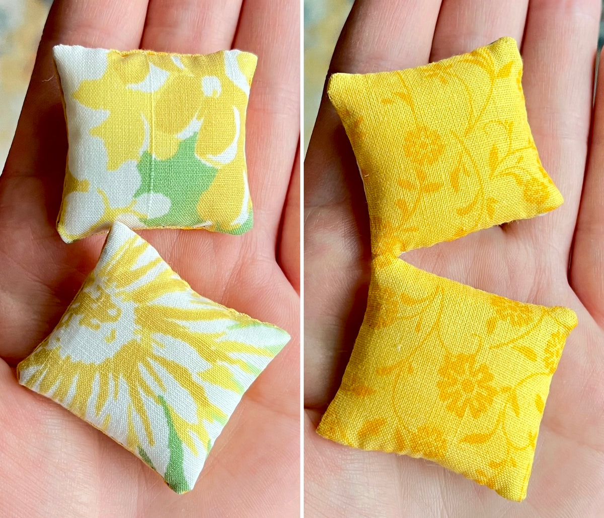 Two small fabric pillows with floral patterns held in hands.