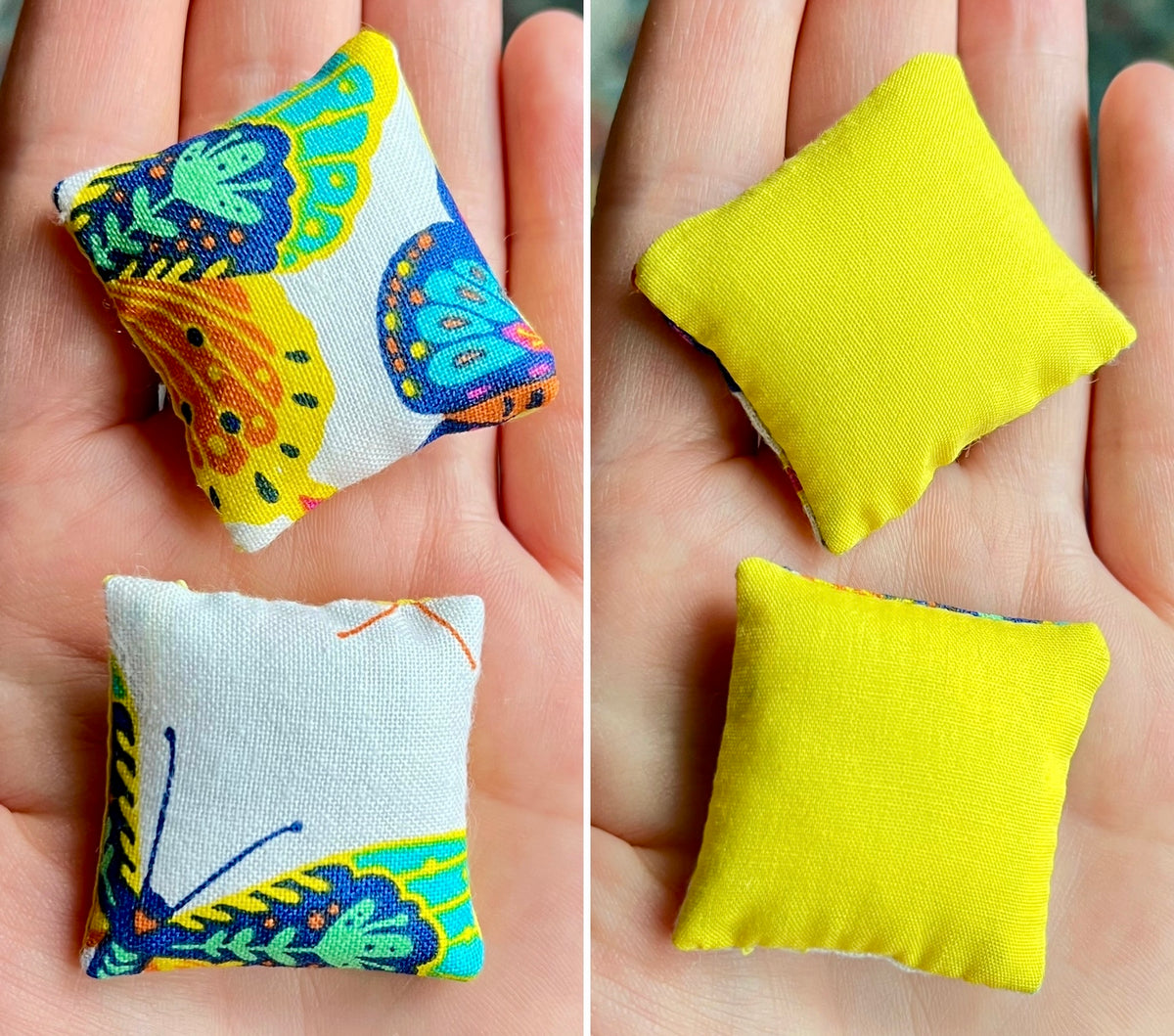 Two small fabric pillows, front with butterfly design and back is plain yellow, held in hands.